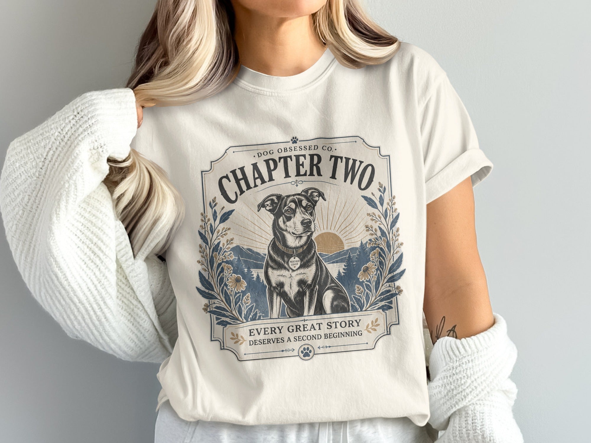 Cream t-shirt with "Chapter Two" graphic and dog sitting by a sunset.