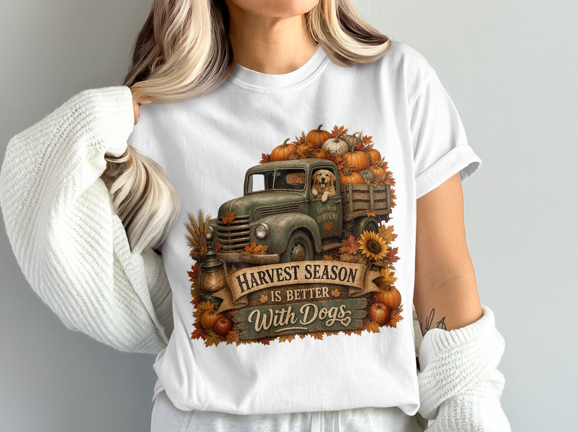 White t-shirt featuring a vintage truck full of pumpkins and a dog, with the text "Harvest season is better with dogs".