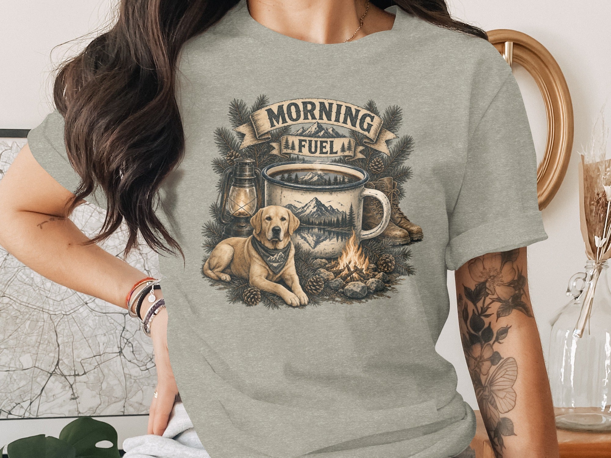 Labrador dog, campfire, coffee mug, lantern, boots, and pine branches with "Morning Fuel" text.