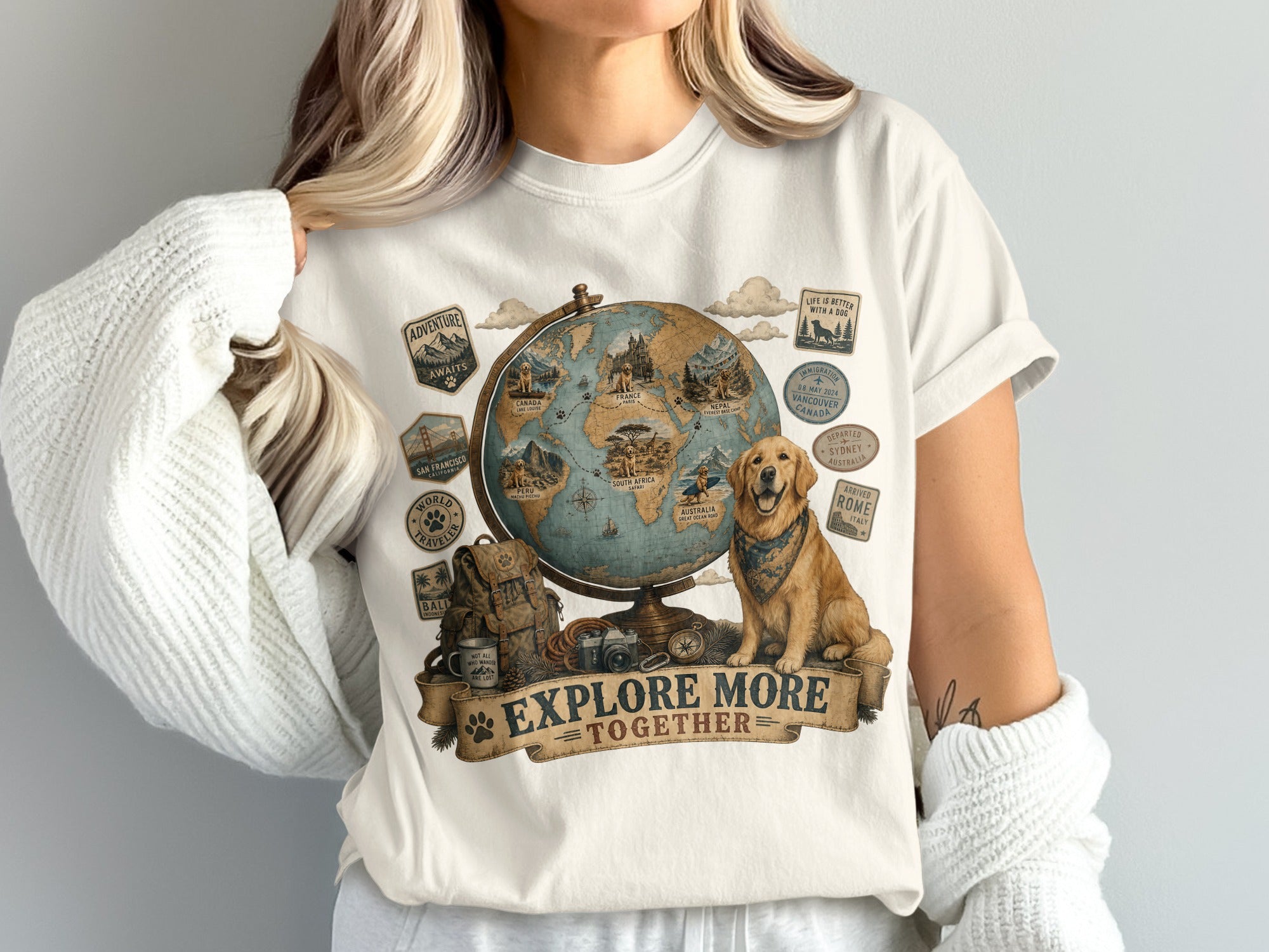 T-shirt with globe, golden retriever, backpack, camera, and travel text "Explore More Together".