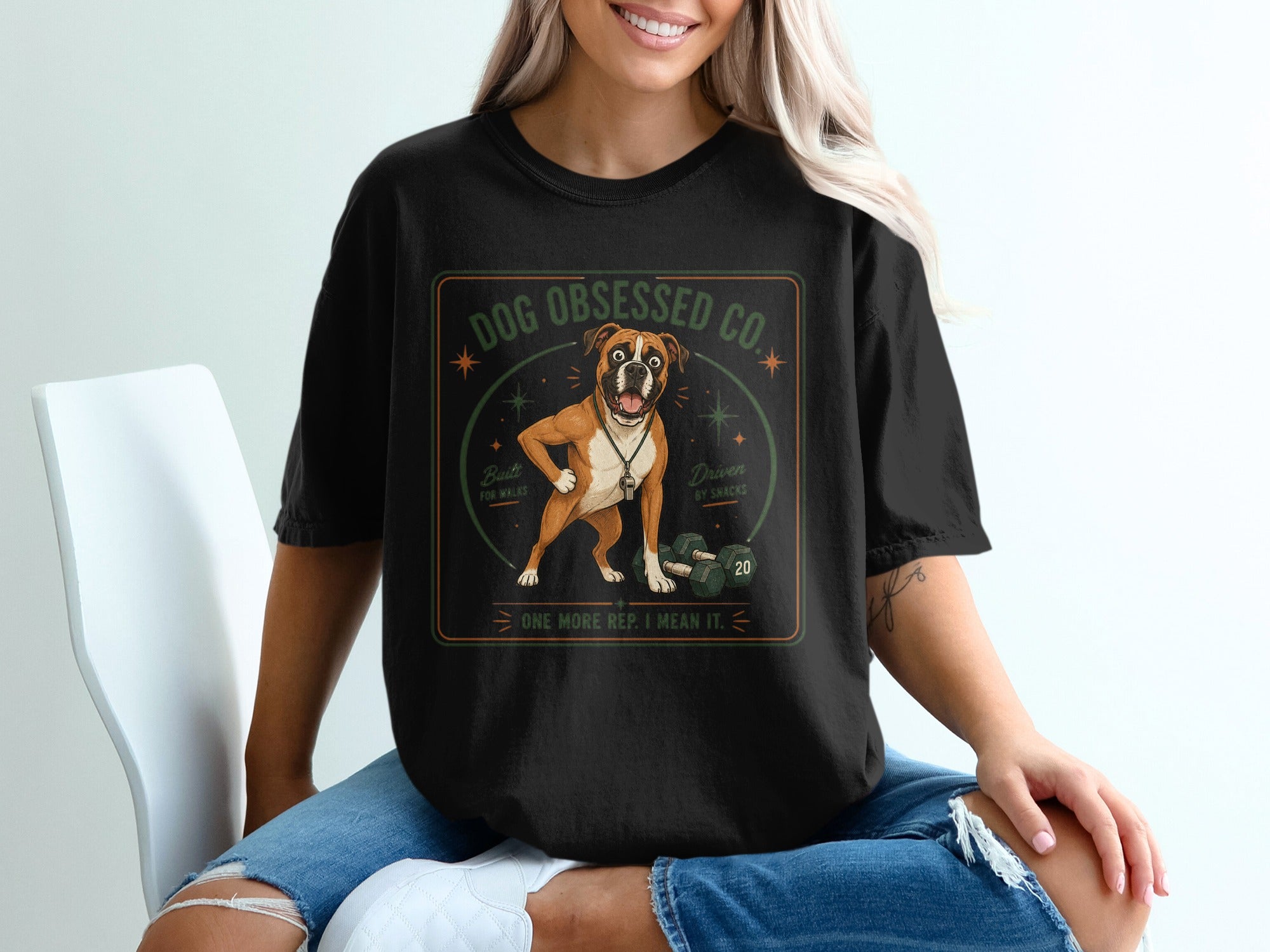 Black t-shirt graphic with boxer dog, dumbbells, and text "Dog Obsessed Co."