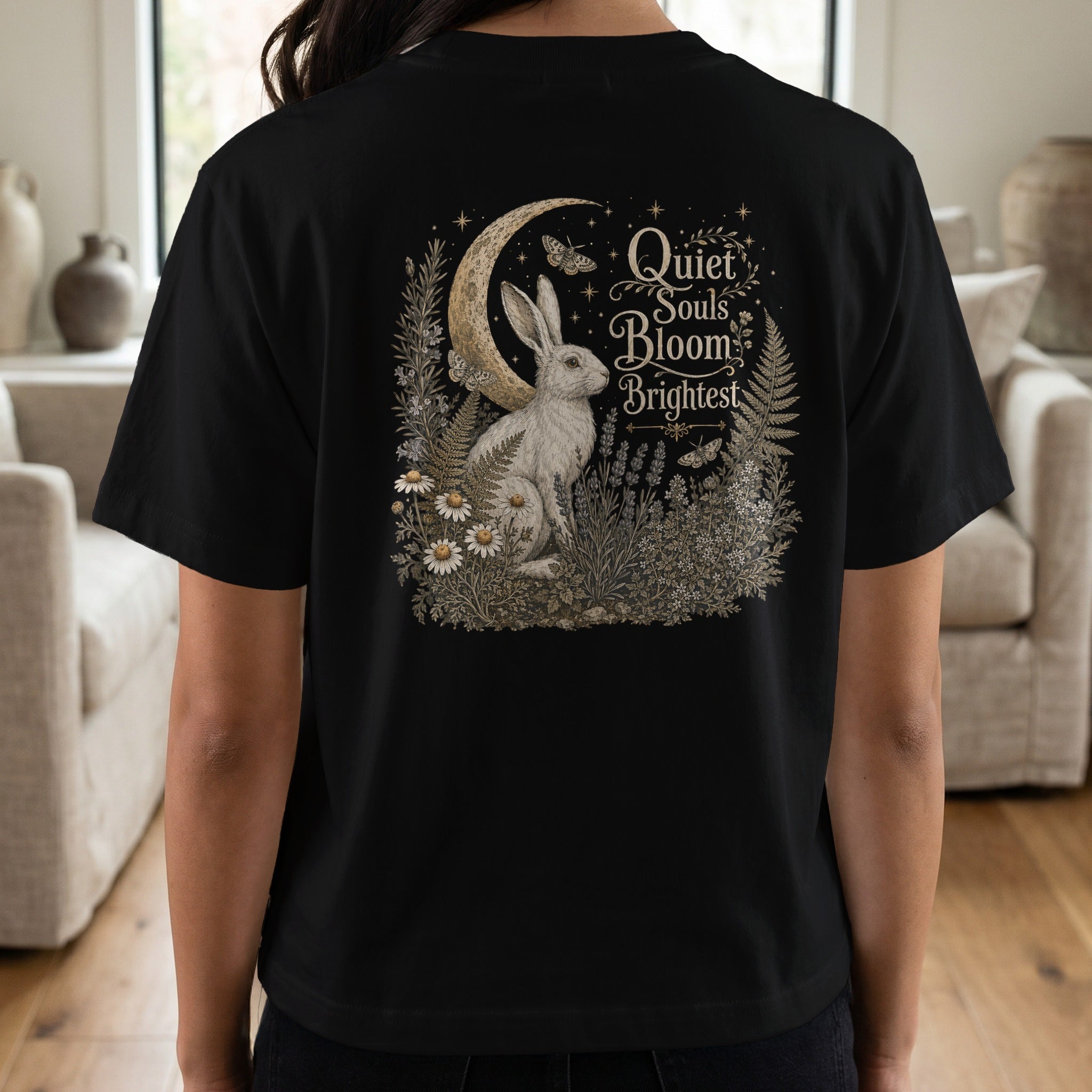 Black t-shirt with a graphic of a rabbit, moon, butterflies, and text "Quiet Souls Bloom Brightest".