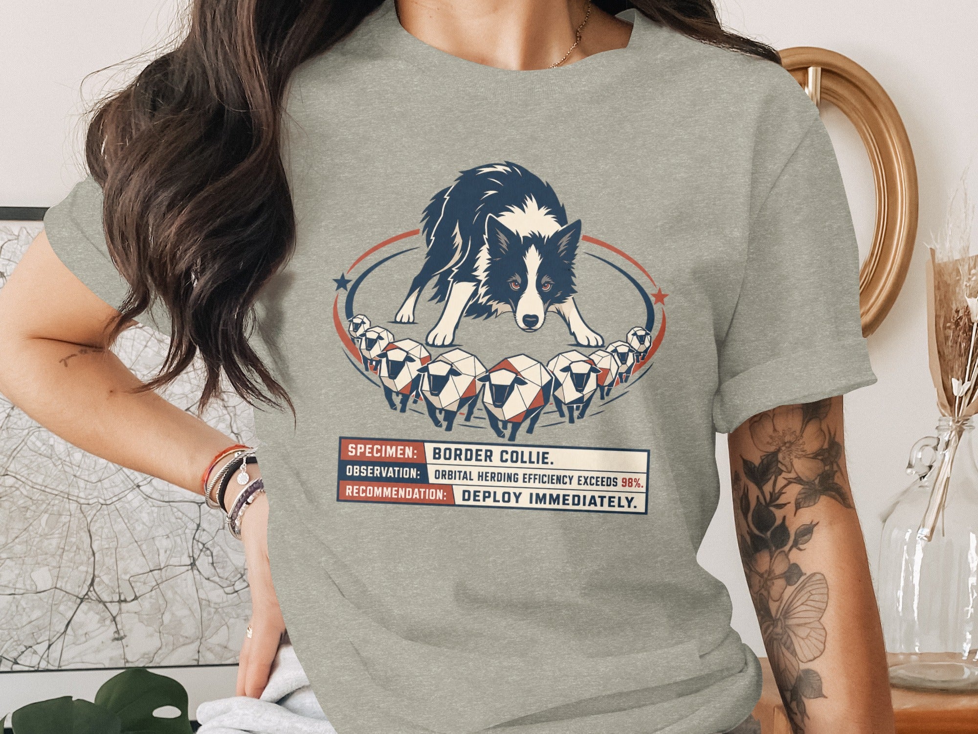 Grey t-shirt with a graphic of a Border Collie herding sheep and text.