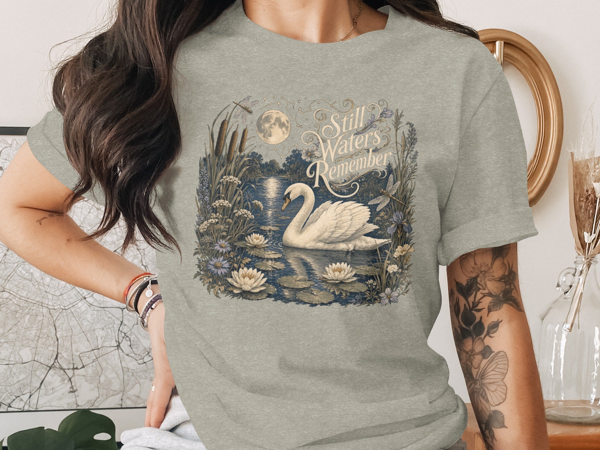 Graceful swan on water with moon and text "Still Waters Remember".