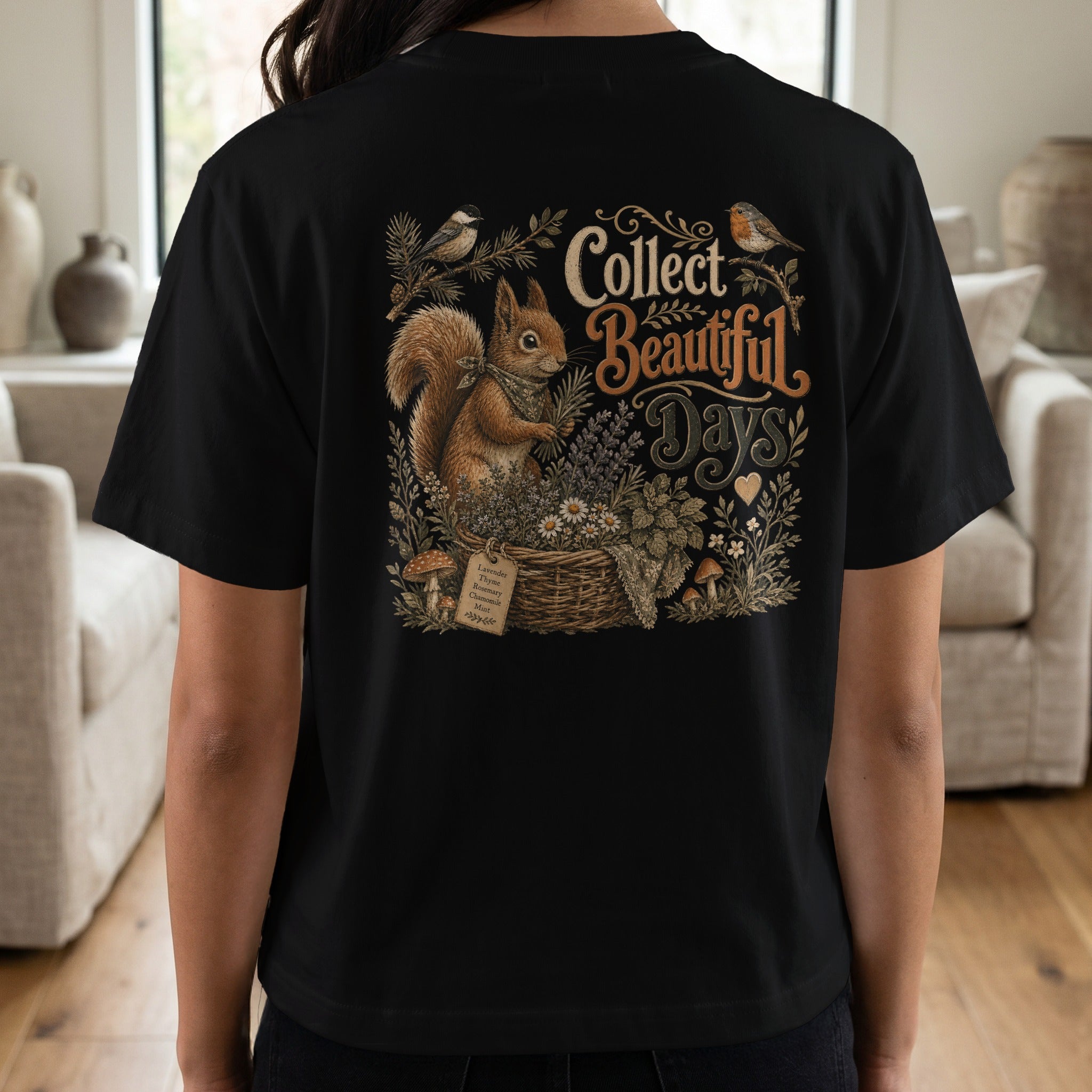 Black t-shirt with squirrel, birds, basket of herbs, and text "Collect Beautiful Days".