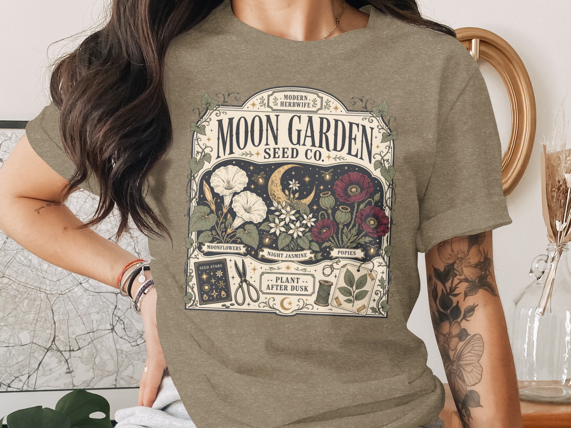 T-shirt with "Moon Garden Seed Co." botanical art featuring moonflowers, poppies, crescent moon, and gardening tools.