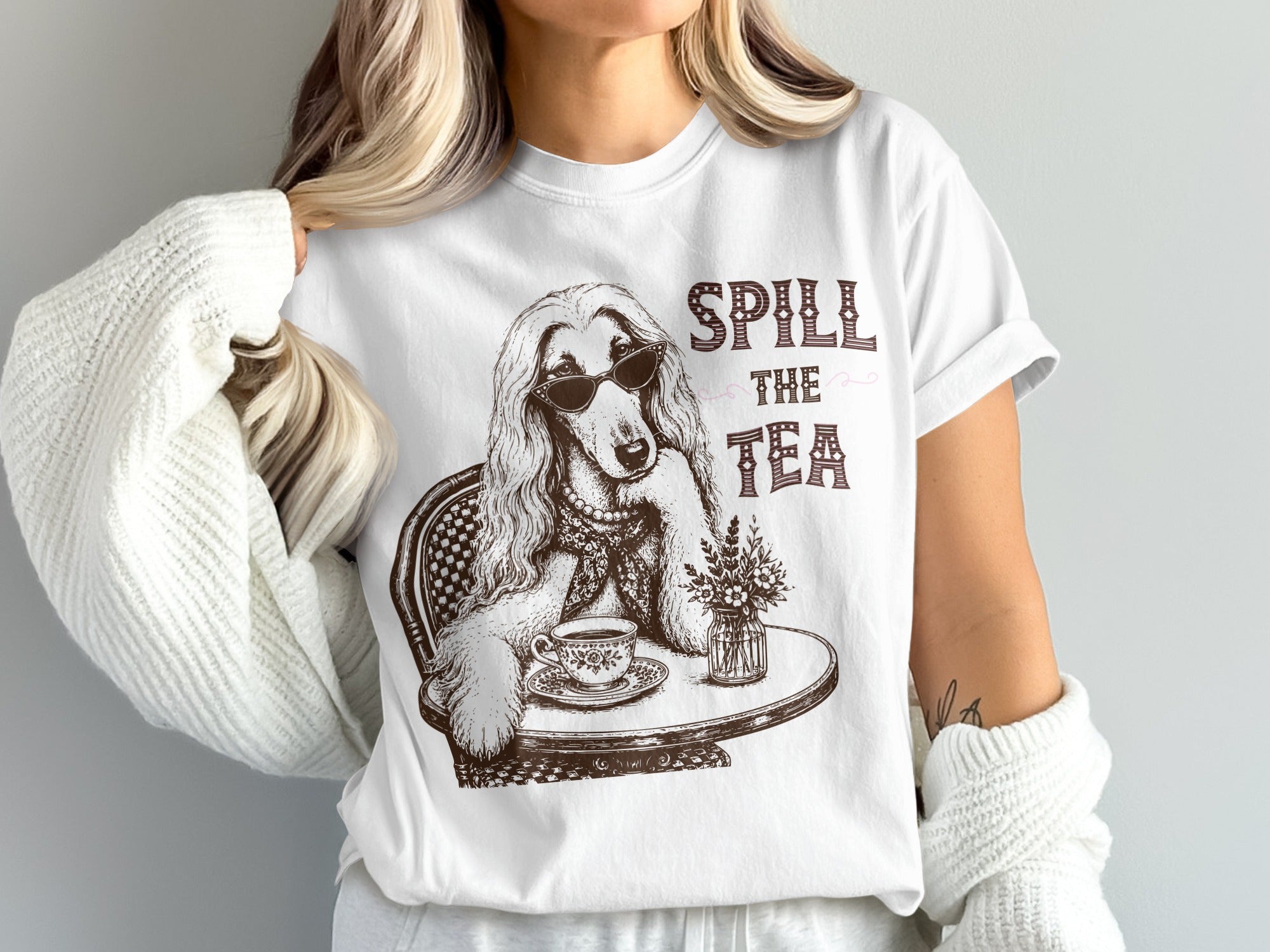 Graphic t-shirt with a dog wearing sunglasses and text "Spill the Tea".
