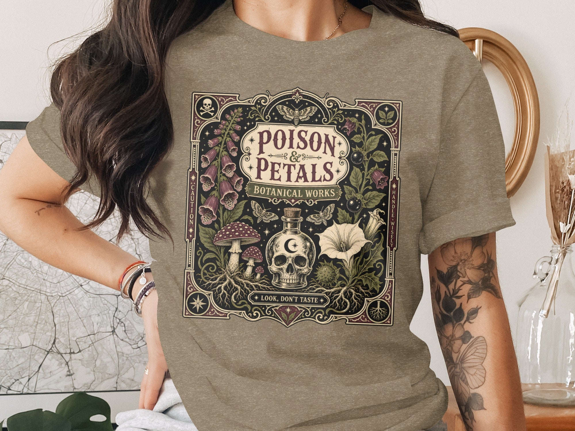 T-shirt with "Poison & Petals Botanical Works" design featuring a skull, mushrooms, and a bottle.