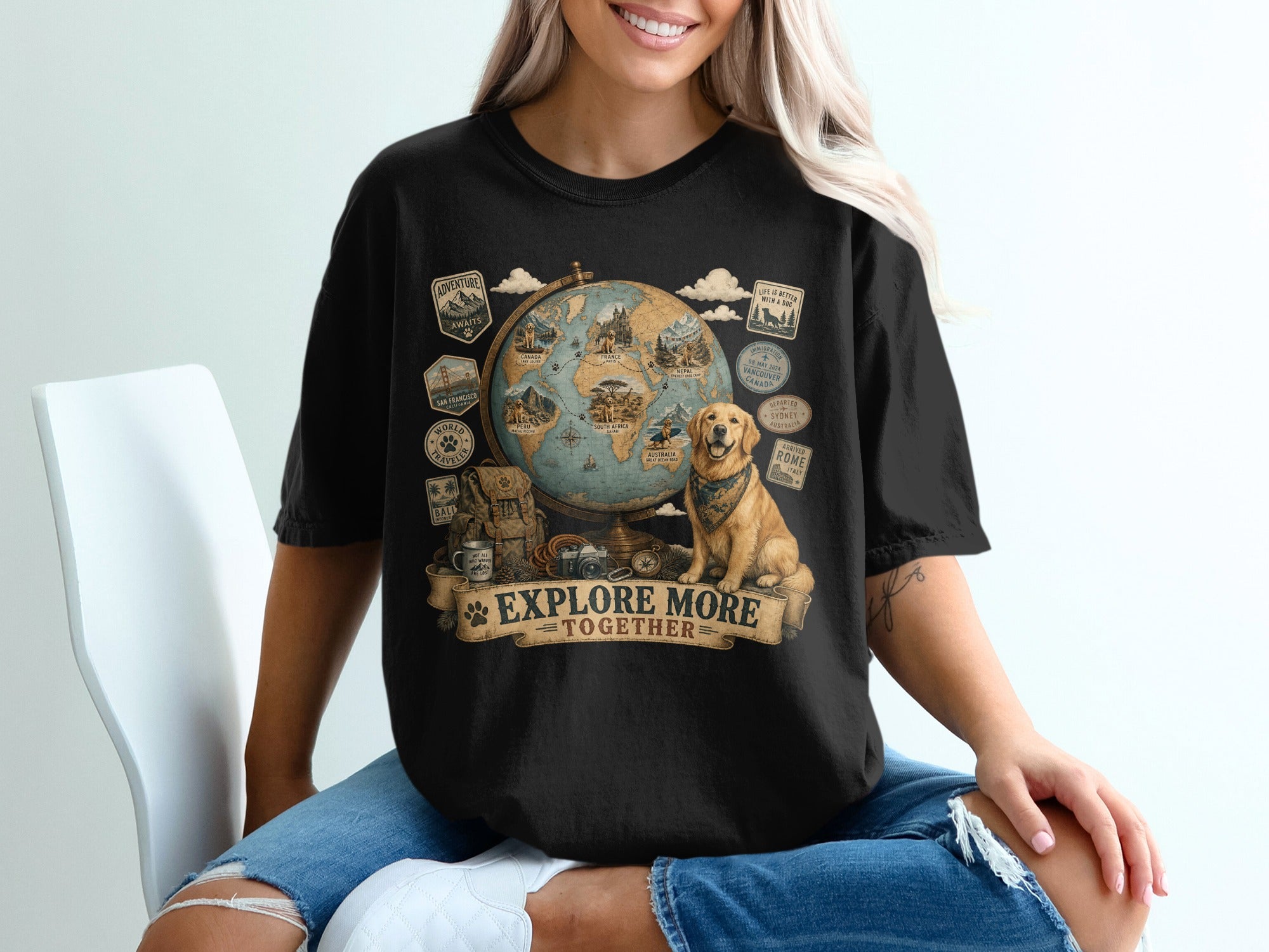 Black t-shirt graphic with globe, dog, backpack, camera, and text "EXPLORE MORE TOGETHER".