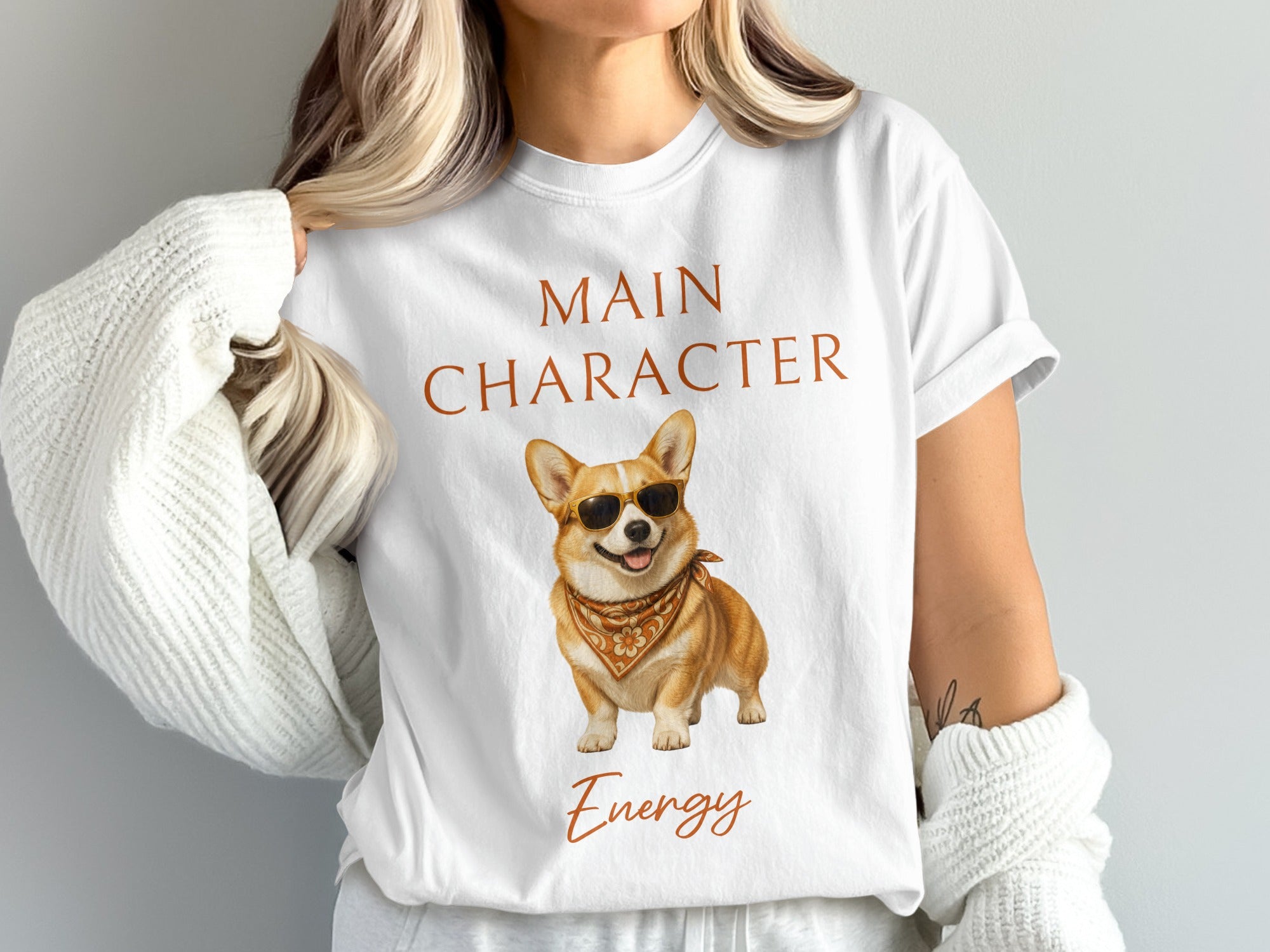 White t-shirt with "Main Character Energy" and a corgi wearing sunglasses and bandana.