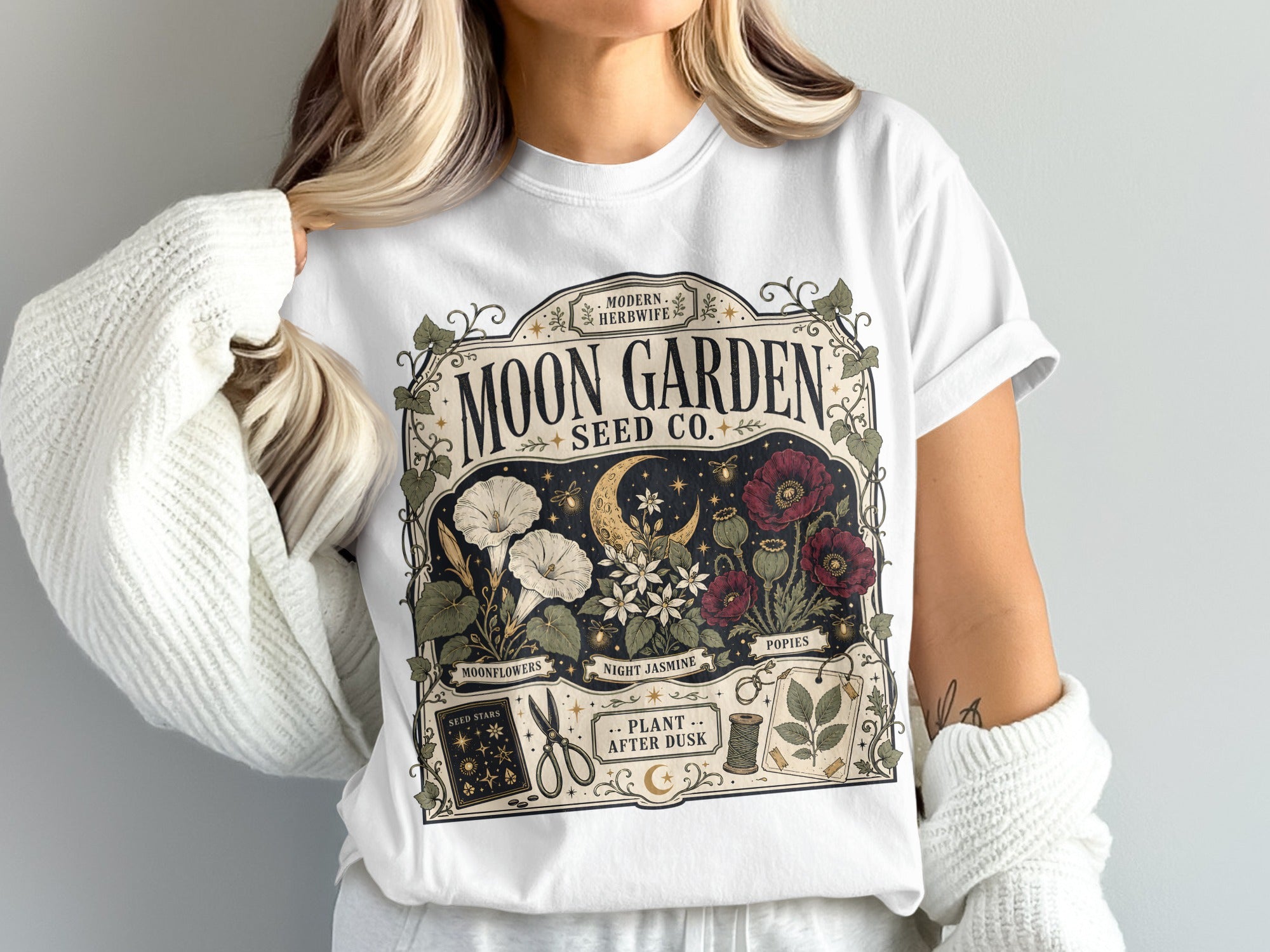 Moon Garden Seed Co. t-shirt with moon, flowers, and gardening tools design.