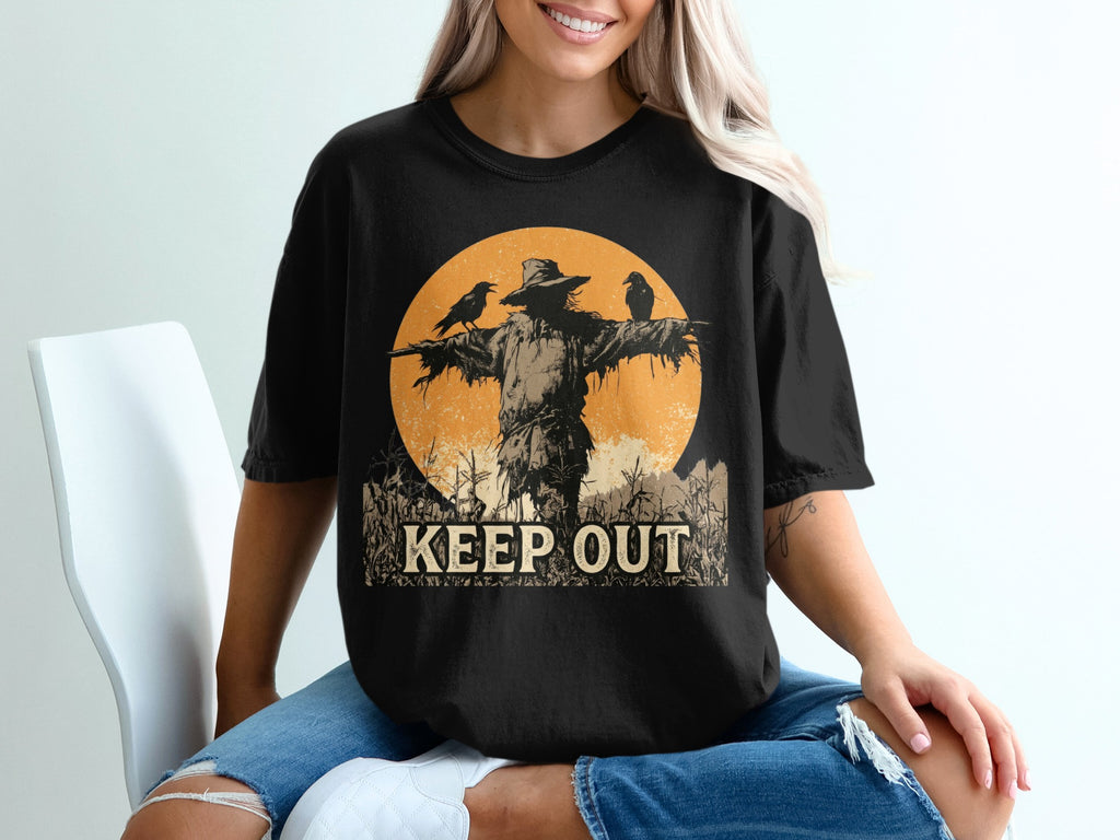 Black t-shirt graphic with scarecrow, crows, and text "KEEP OUT".