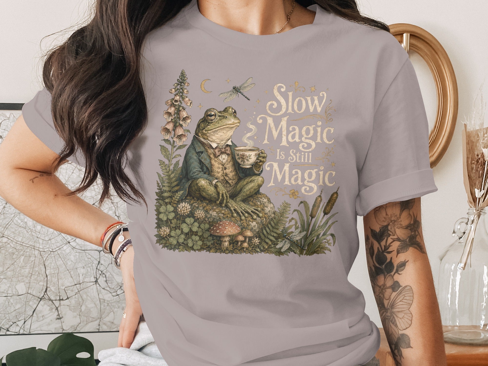 Frog in a suit holding a teacup with text "Slow Magic Is Still Magic".