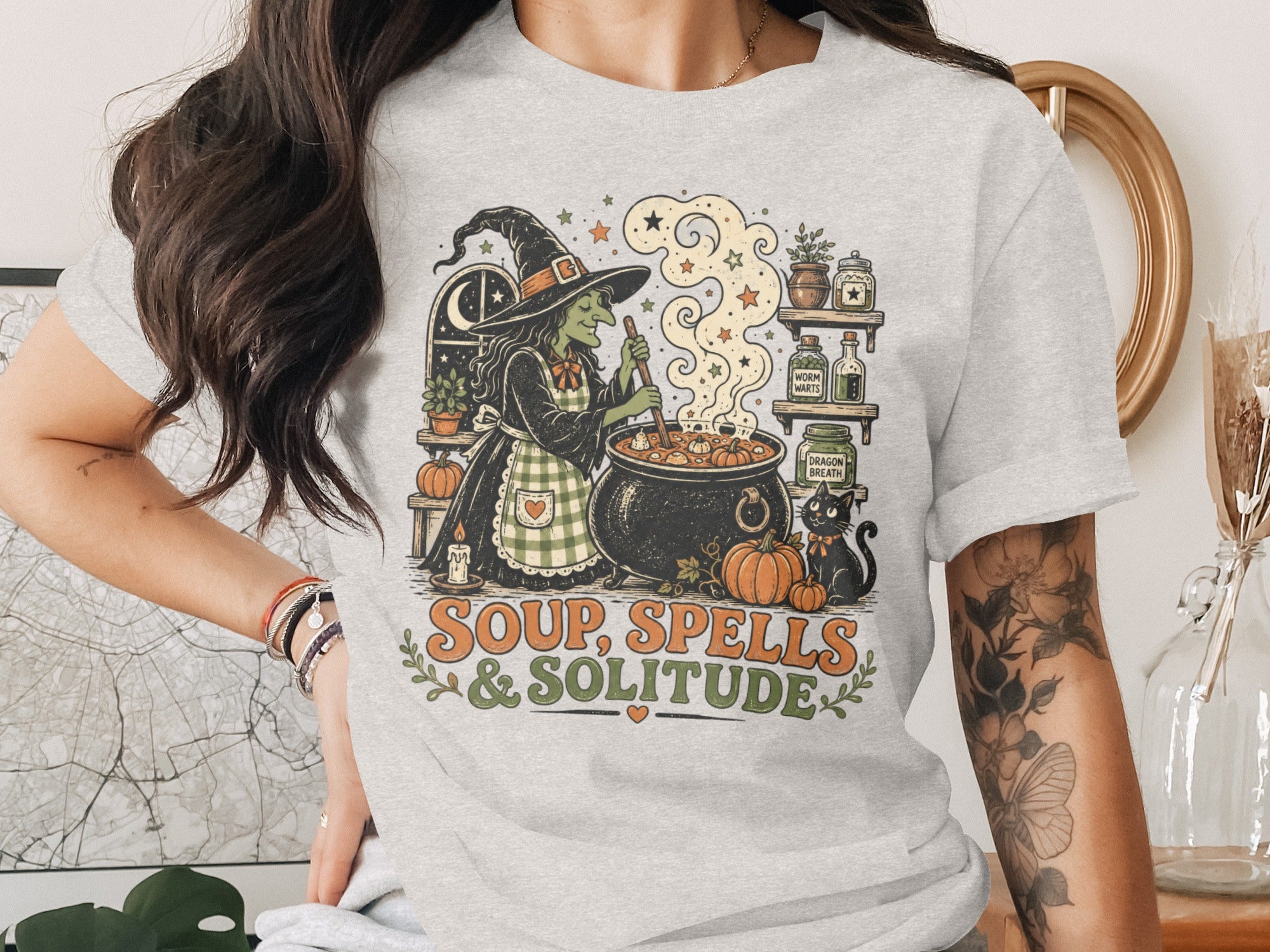 Witch stirs cauldron with black cat and text "Soup, Spells & Solitude".