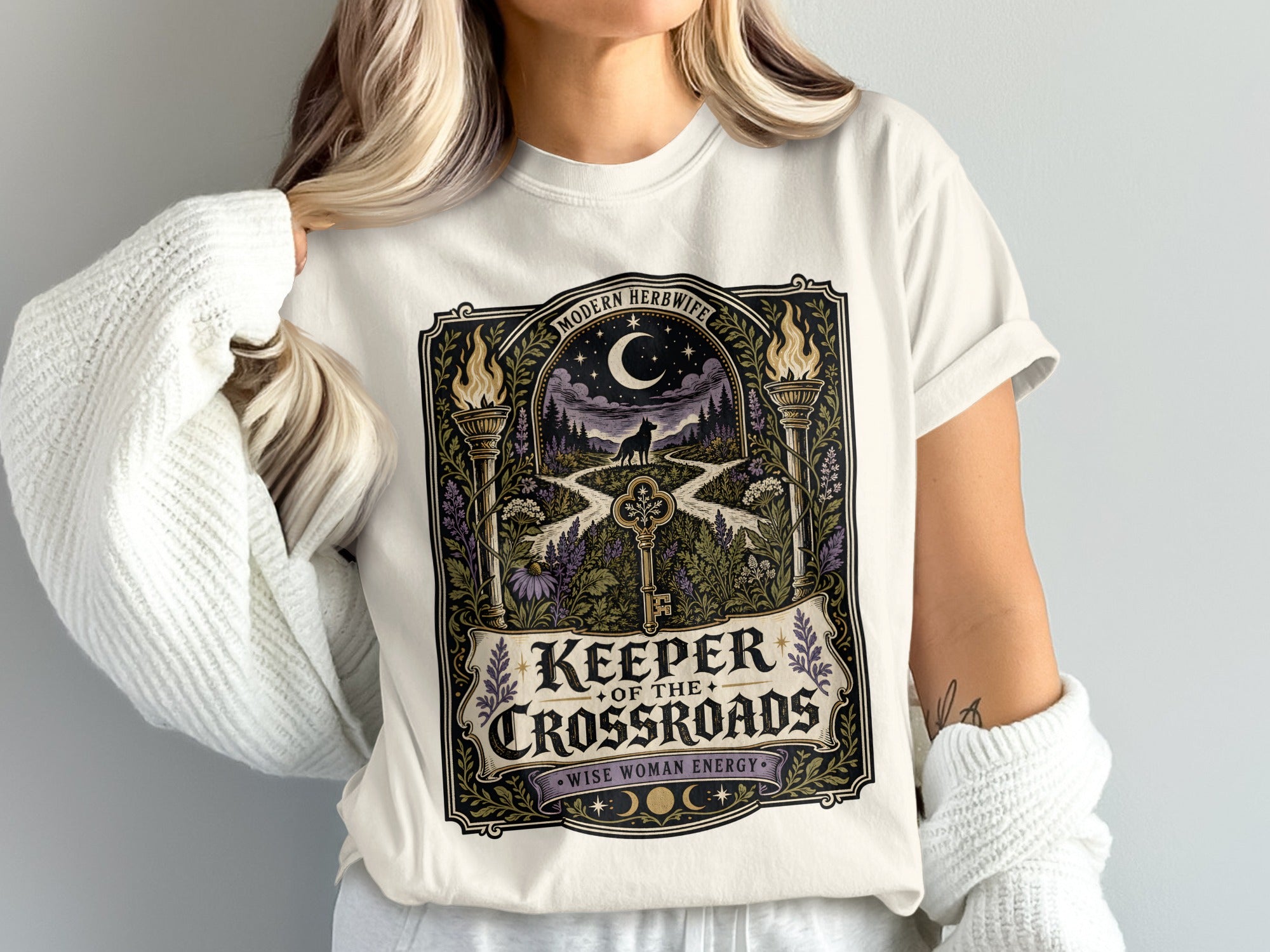 White t-shirt with "Keeper of the Crossroads" graphic featuring a wolf and a key.