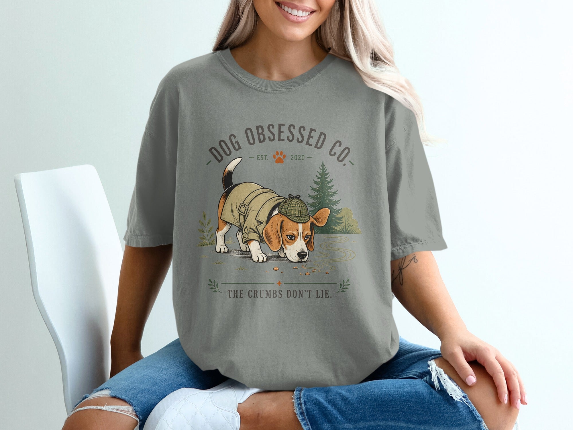 Beagle in coat and hat smelling crumbs with text "Dog Obsessed Co. Est. 2020 The Crumbs Don't Lie."