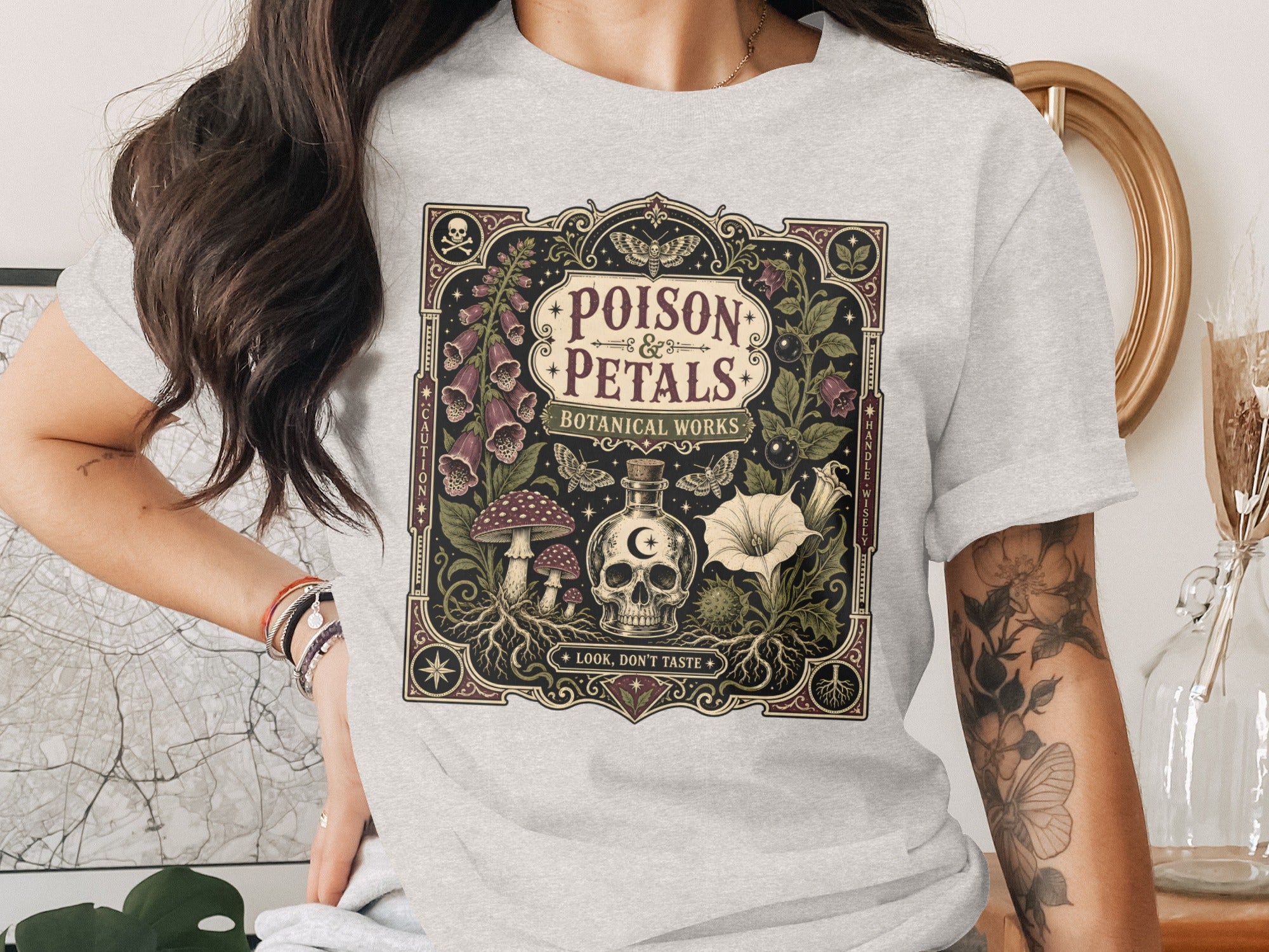 T-shirt with "Poison & Petals Botanical Works" design featuring skull and botanicals.