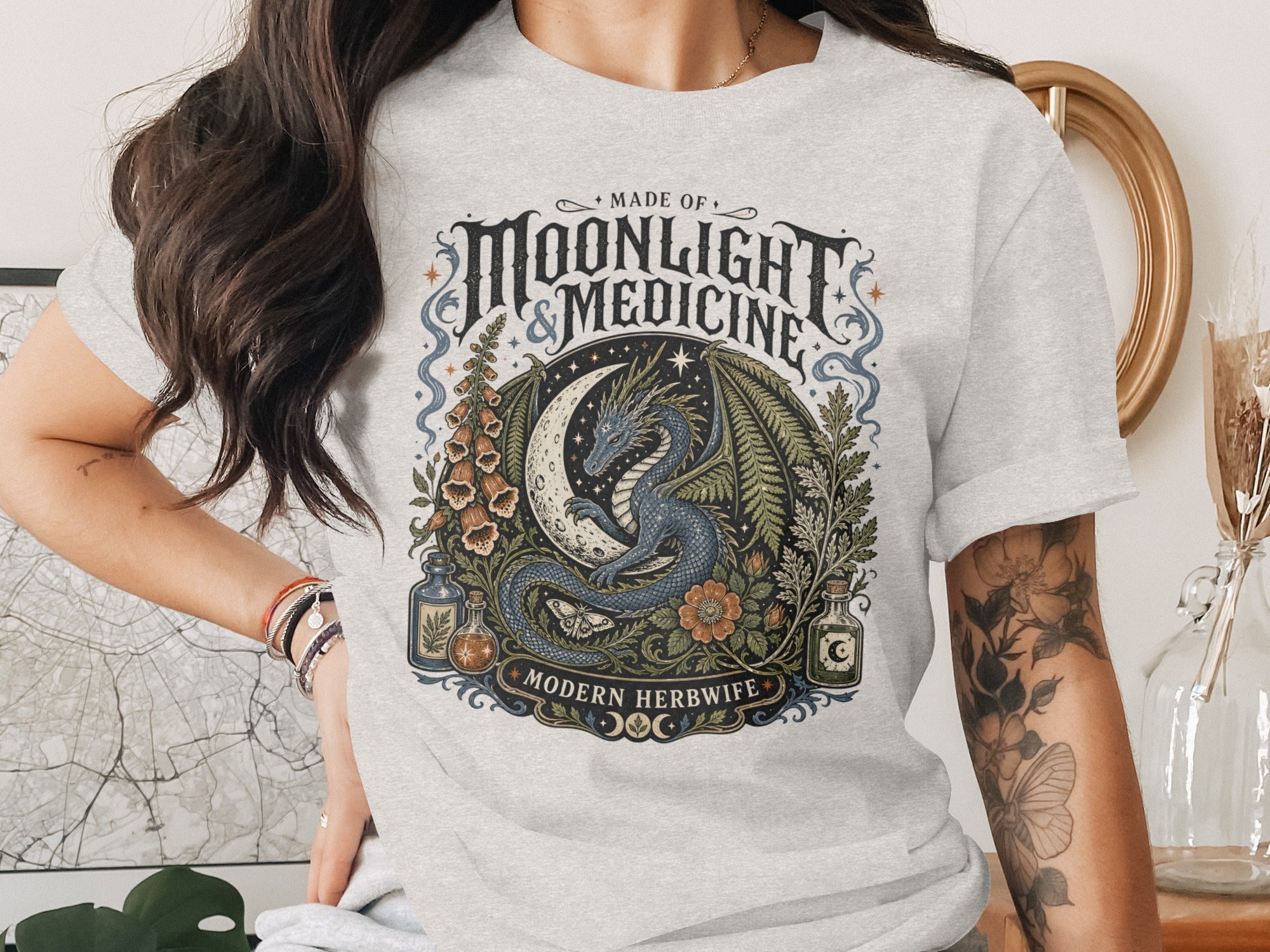 Grey t-shirt with "Made of Moonlight & Medicine Modern Herbwife" text and dragon graphic.