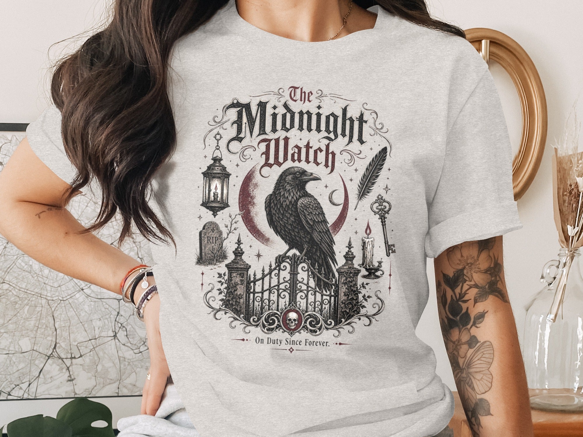 The Midnight Watch t-shirt features a raven, crescent moon, gate, and gothic embellishments.