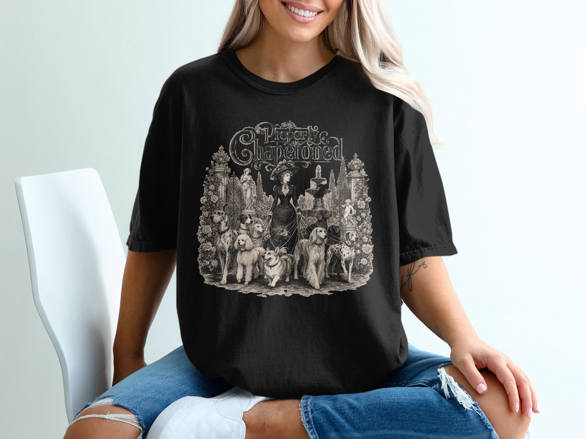 Black t-shirt with vintage "Properly Chaperoned" text and dogs illustration design.