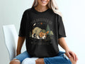 Black t-shirt with a beagle dog wearing a hat and jacket, smelling crumbs.