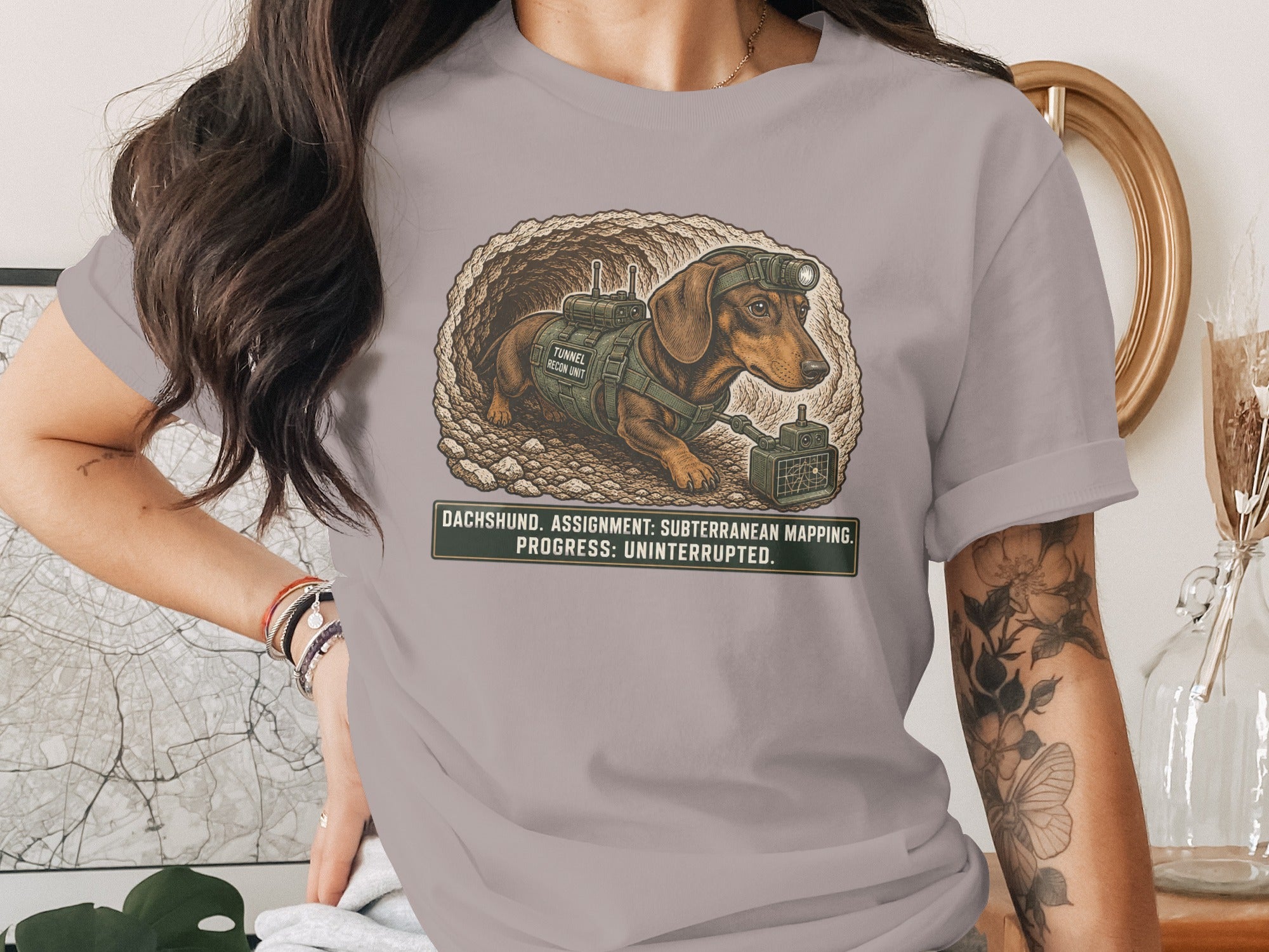 Dachshund with headlamp and gear in tunnel, text reads "DACHSHUND. ASSIGNMENT: SUBTERRANEAN MAPPING. PROGRESS: UNINTERRUPTED."