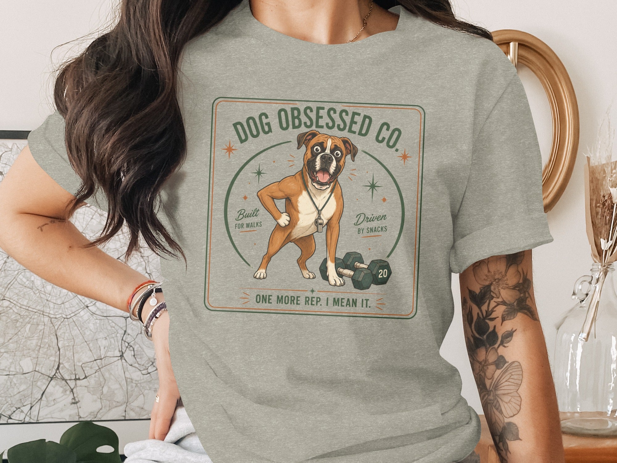 Boxer dog with dumbbells wearing whistle necklace, "Dog Obsessed Co." text.