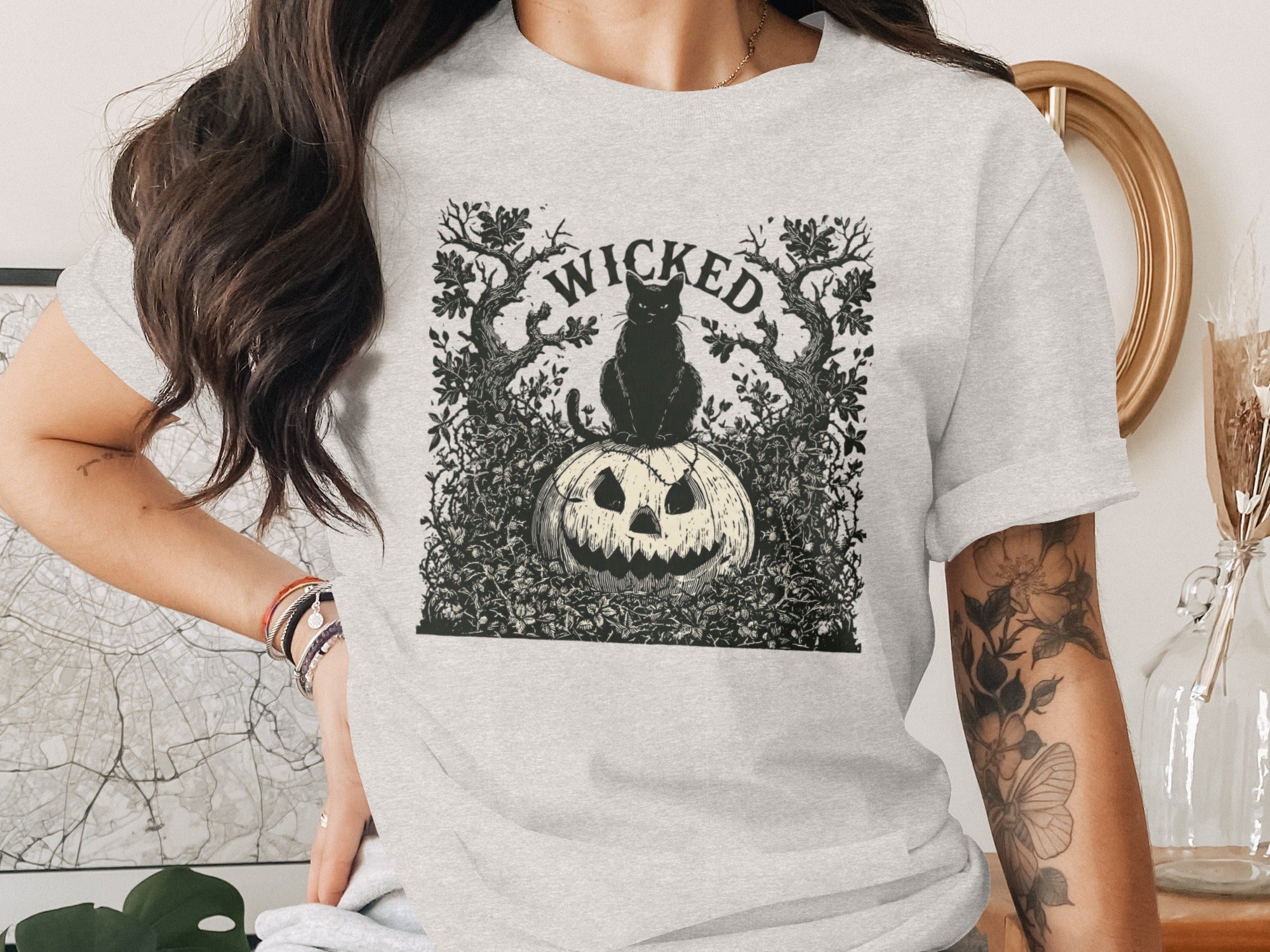 Grey t-shirt with a black and white graphic of a black cat on a pumpkin labeled "WICKED."