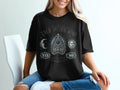 Black t-shirt with a ouija board design featuring sun, moon, and celestial elements.