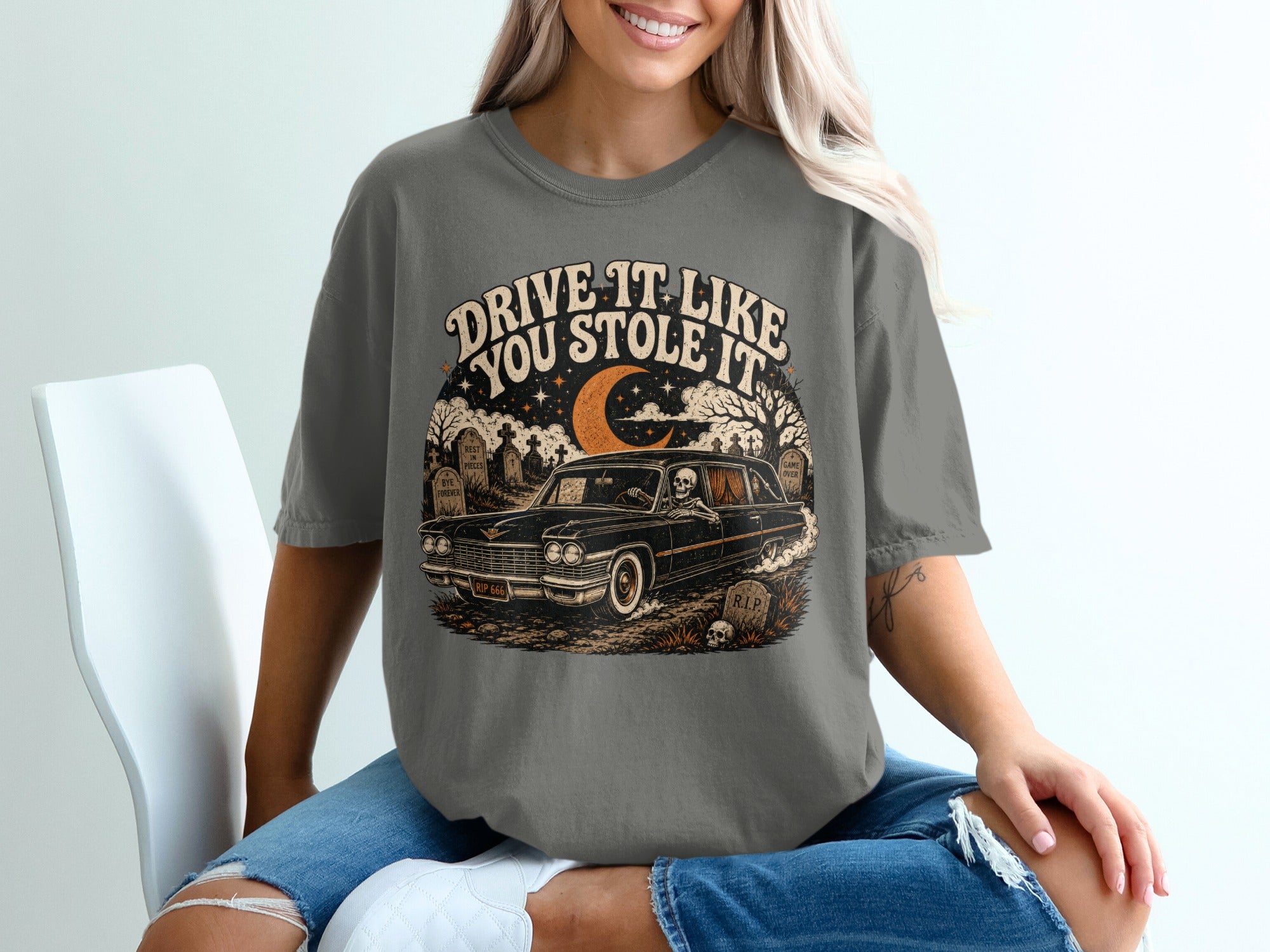 Dark t-shirt with "Drive it like you stole it" text and graveyard scene.