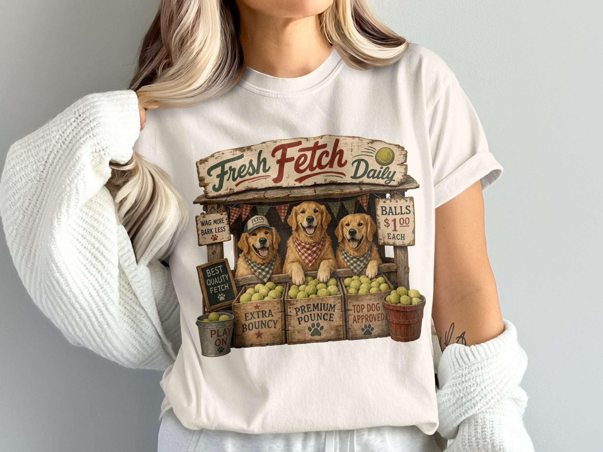 Three golden retrievers at a stand labeled "Fresh Fetch Daily" selling tennis balls.
