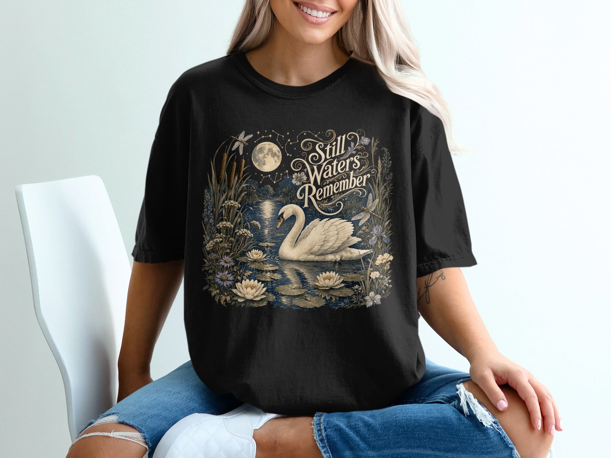 Black t-shirt with a moonlit swan and water lilies design.