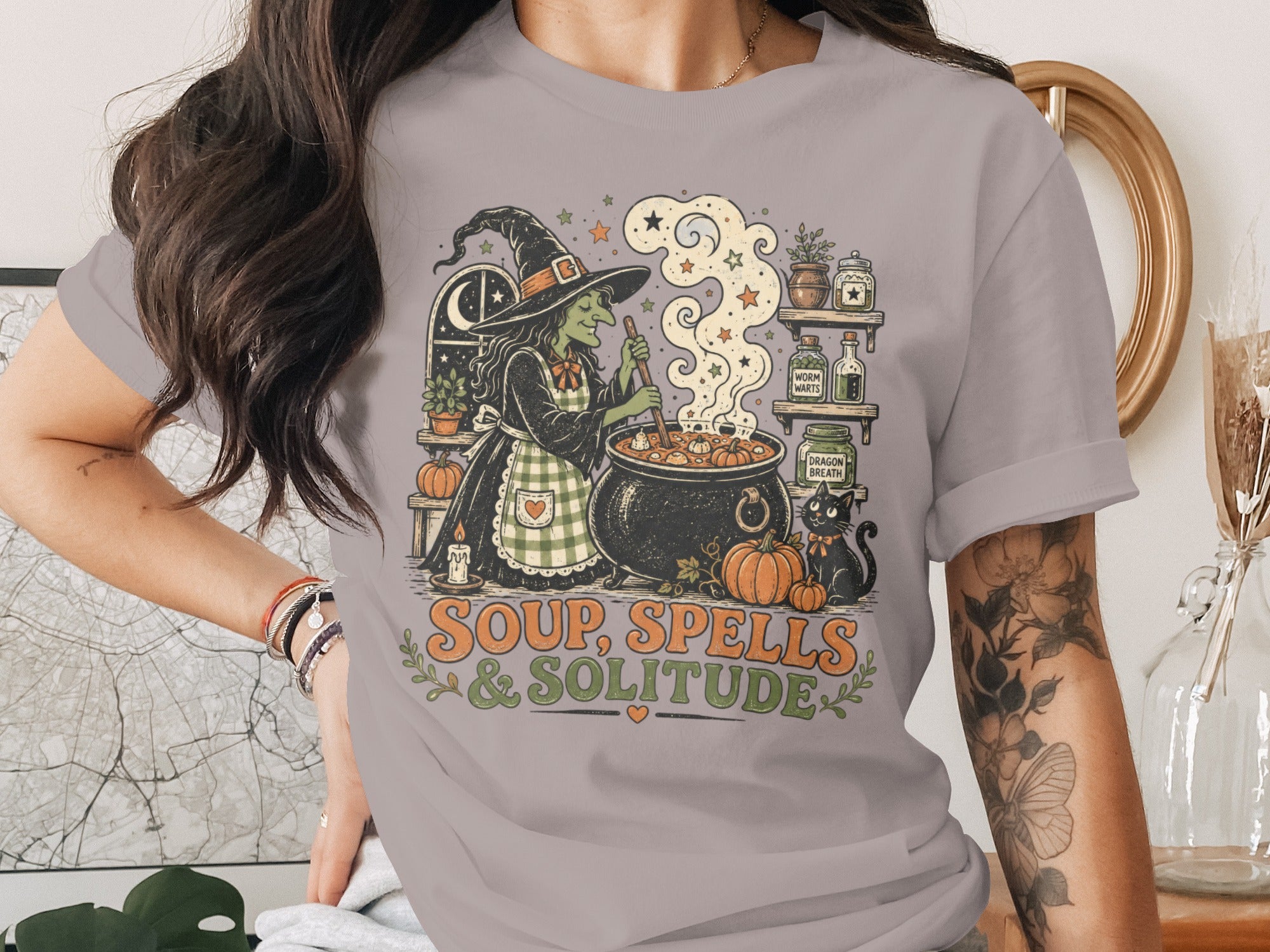 Witch stirring cauldron with black cat, text reads Soup, Spells & Solitude.