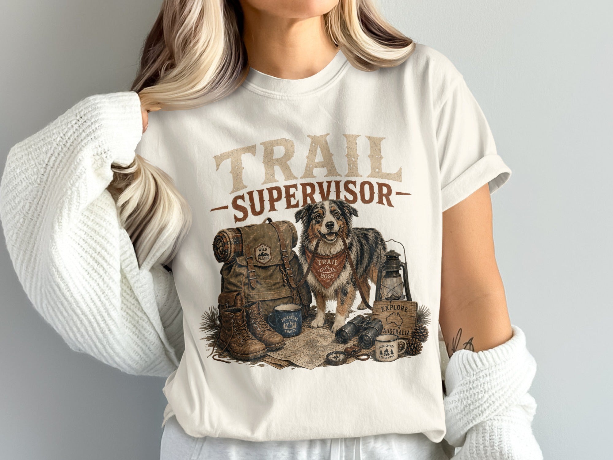 T-shirt with "TRAIL SUPERVISOR" text, dog, backpack, boots, and camping gear.