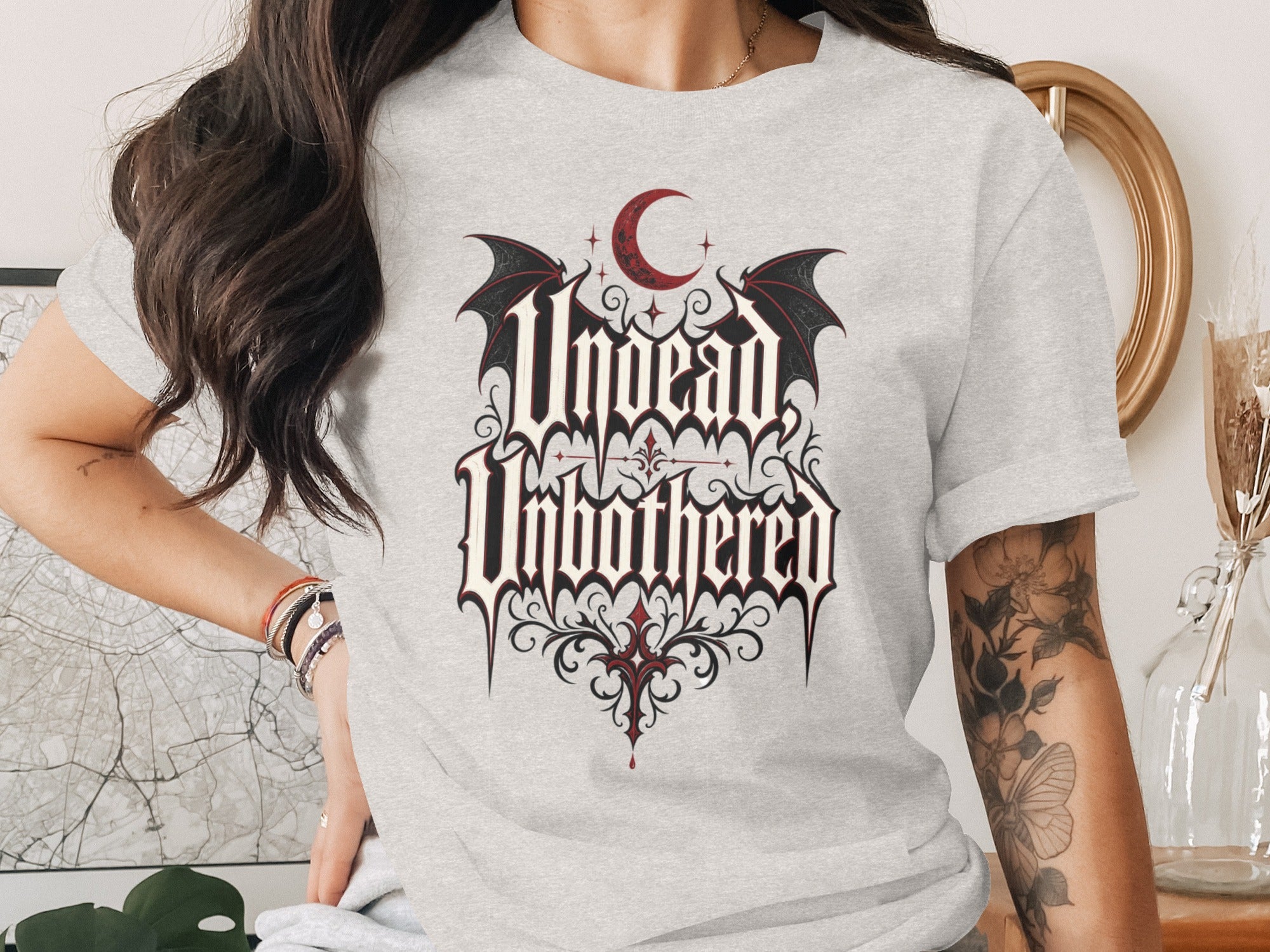 Light grey t-shirt with "Undead Unbothered" gothic text design and crescent moon.