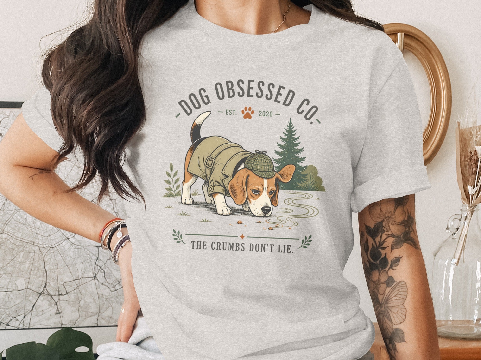 Light grey t-shirt featuring a beagle in a coat and hat, with "DOG OBSESSED CO." and "THE CRUMBS DON'T LIE."
