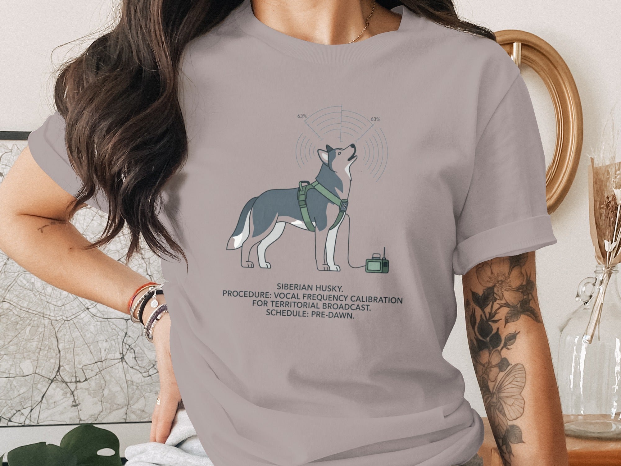 T-shirt graphic of a Siberian Husky with a harness, broadcasting signal and equipment.