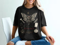 Black t-shirt with Cryptid Research Society graphic featuring a mothman, compass, and evidence tag.