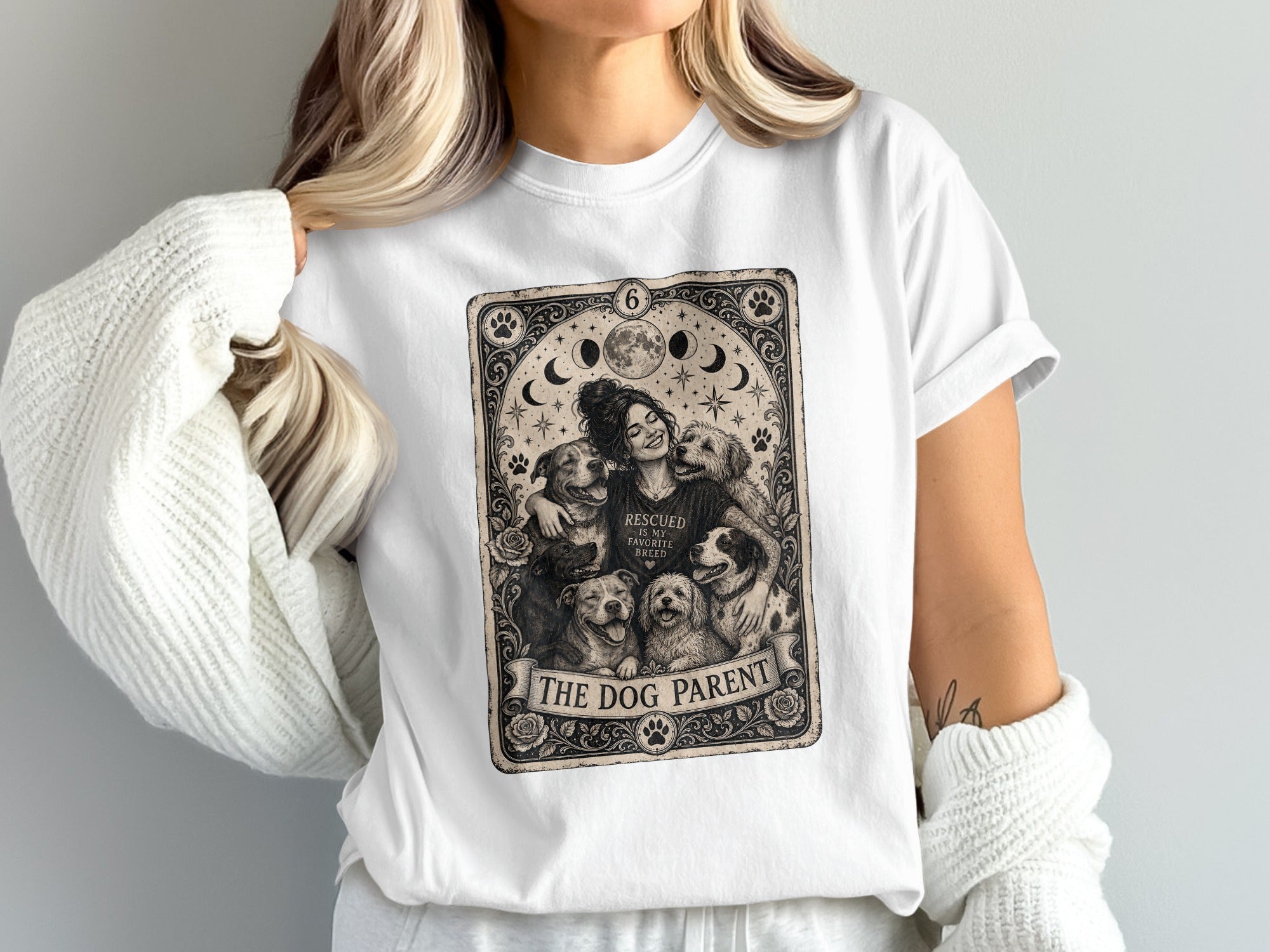 White t-shirt with a distressed tarot card design featuring a woman embracing dogs and the text "The Dog Parent".