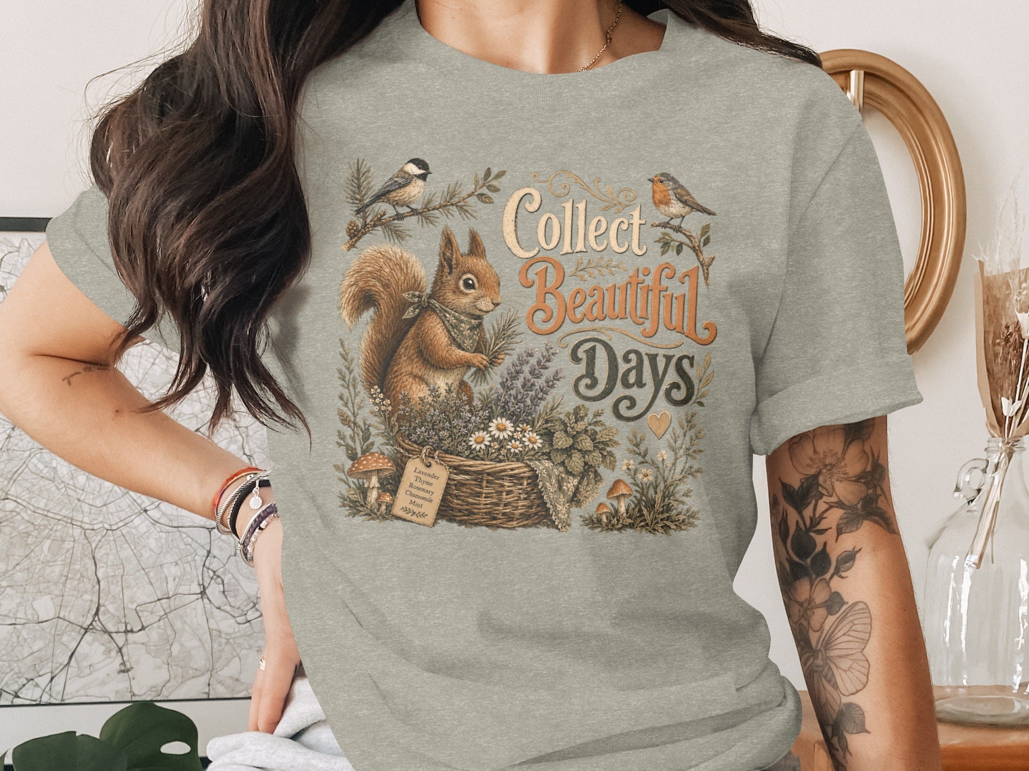 Squirrel, birds, basket with flowers, and text "Collect Beautiful Days" on gray t-shirt.