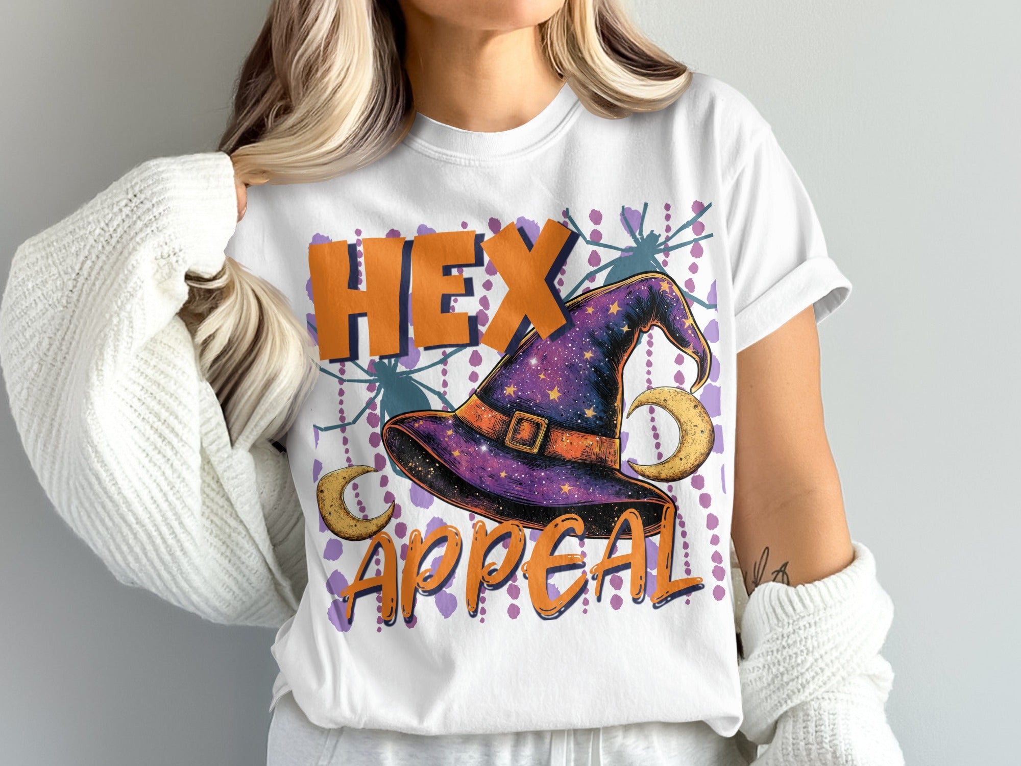White t-shirt with "HEX APPEAL" text, a witch hat, moons, and spiders.