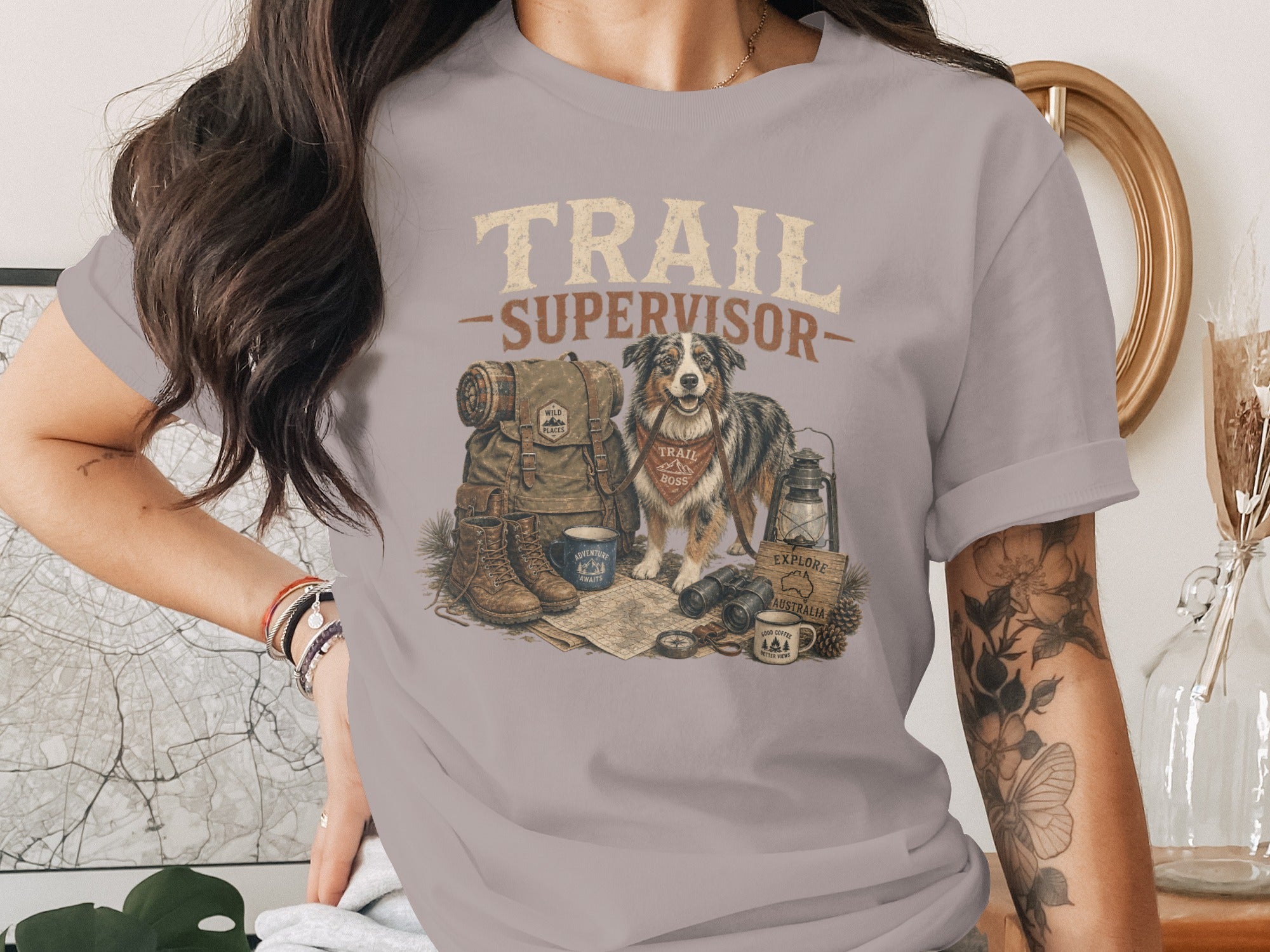 T-shirt with "TRAIL SUPERVISOR" text, dog, backpack, boots, and camping gear.