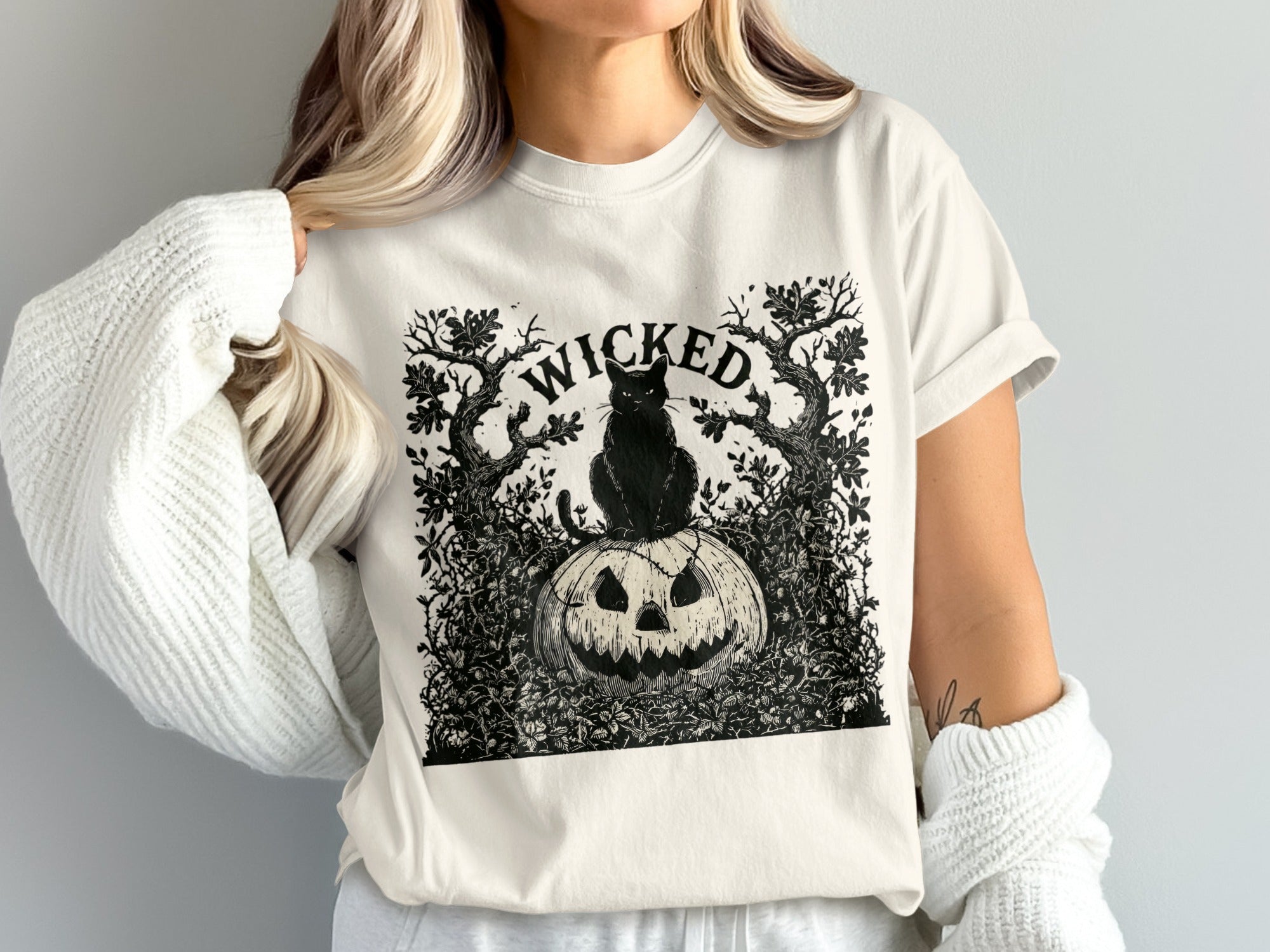 Black cat on pumpkin with "WICKED" text framed by trees and vines.