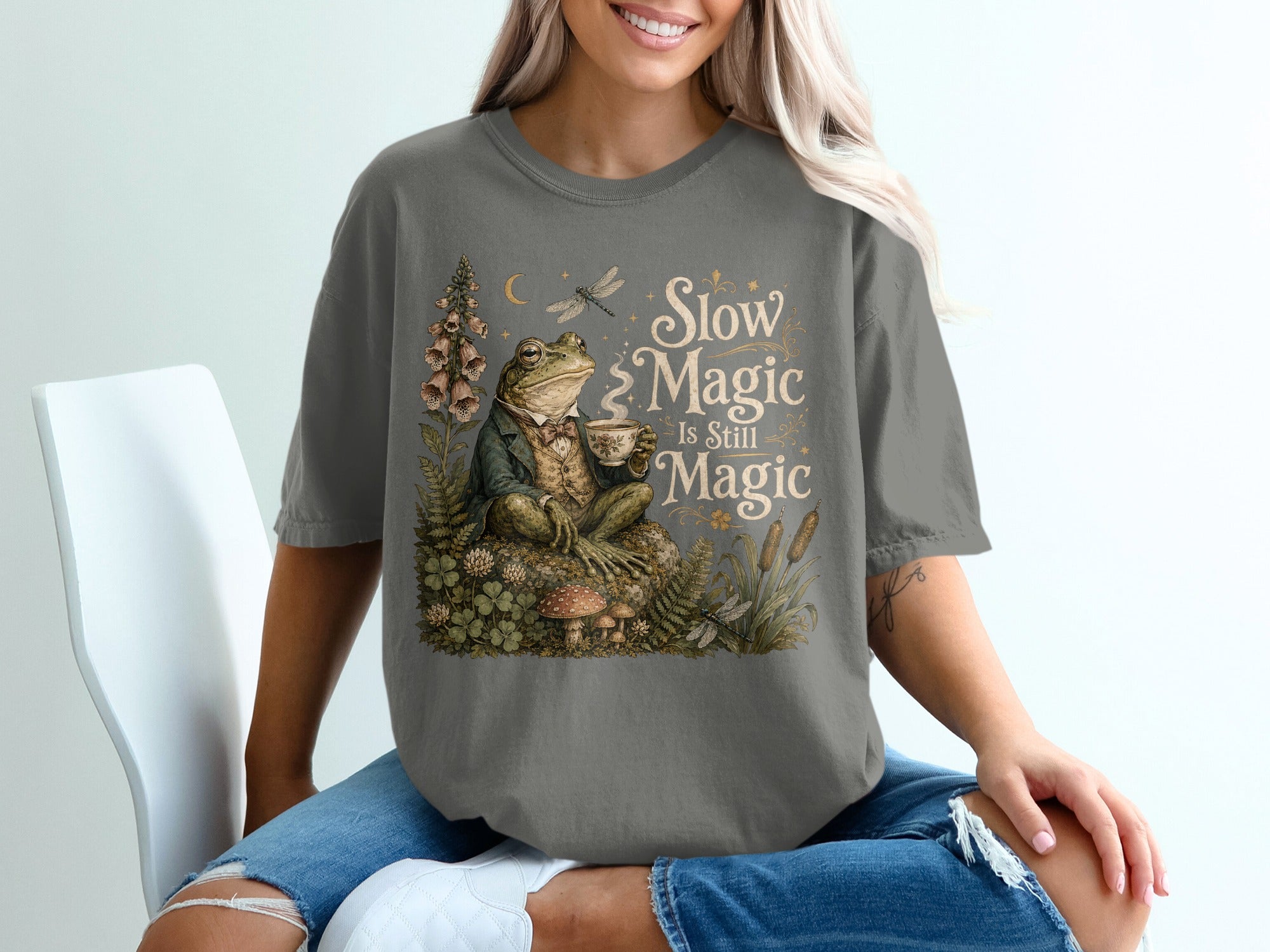 T-shirt featuring a dapper frog drinking tea with the text "Slow Magic Is Still Magic."