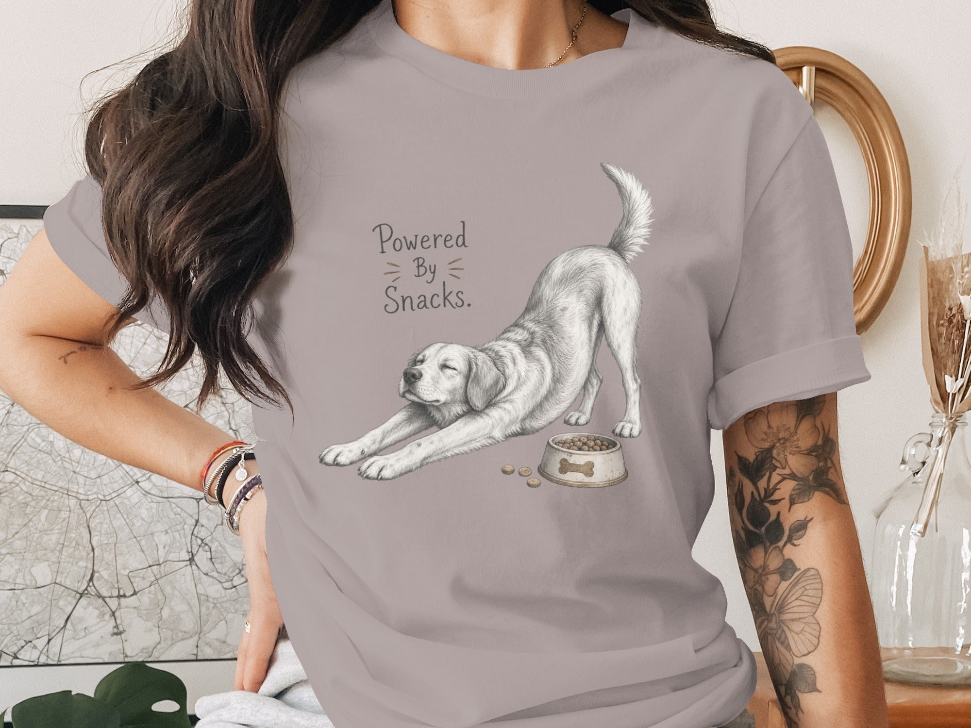 T-shirt with a white dog stretching and a food bowl with text "Powered By Snacks."