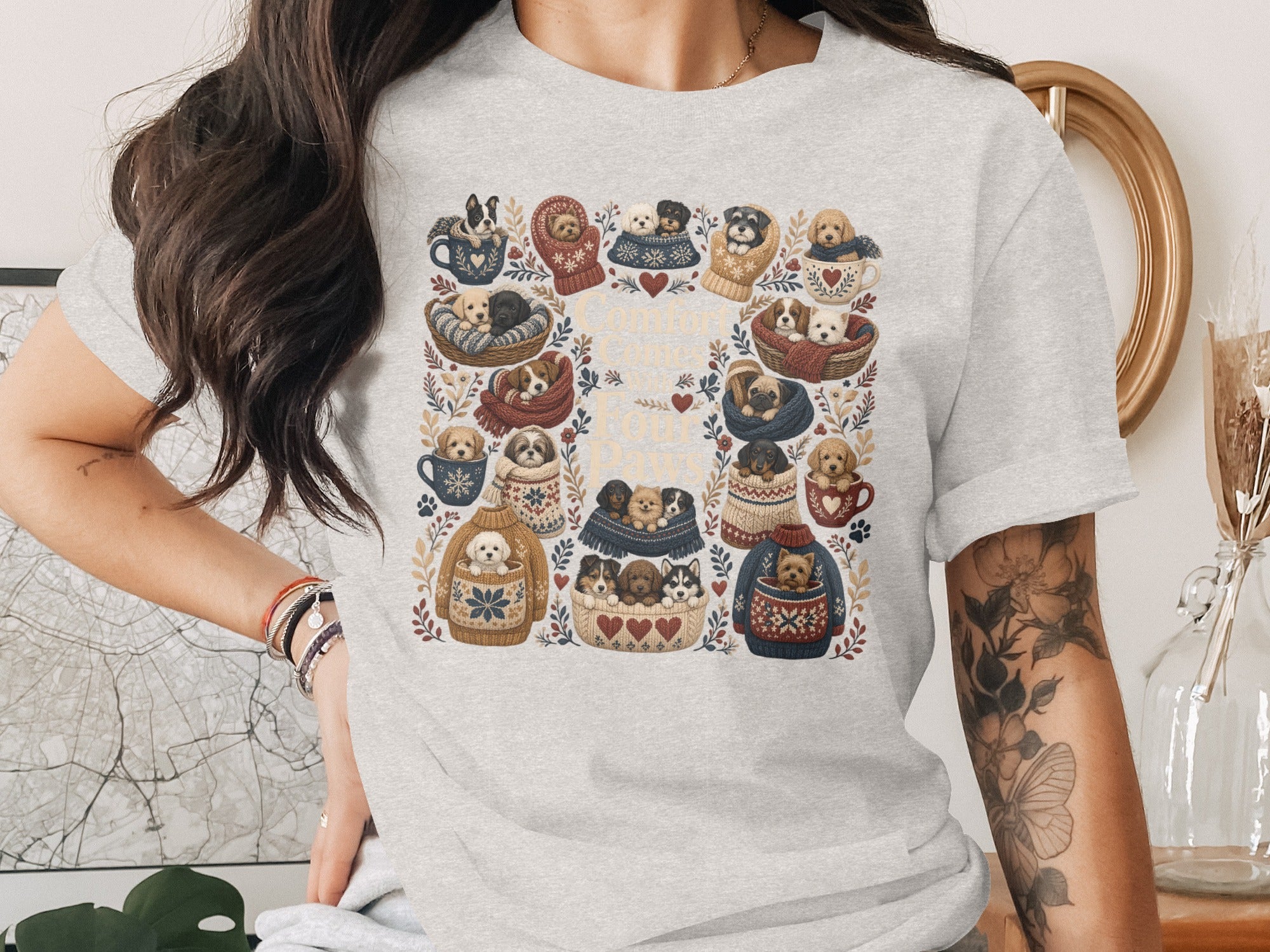 Grey t-shirt with a floral border design featuring numerous puppies in mugs and knitted sweaters.