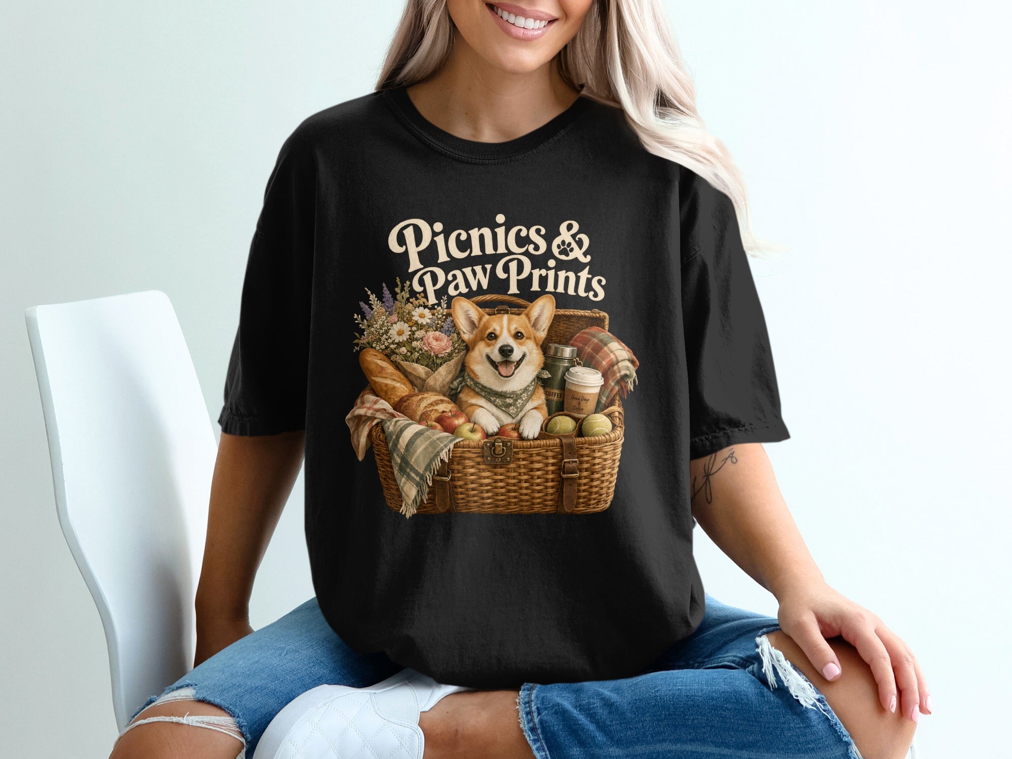 Black t-shirt with graphic "Picnics & Paw Prints" and a corgi in a picnic basket.