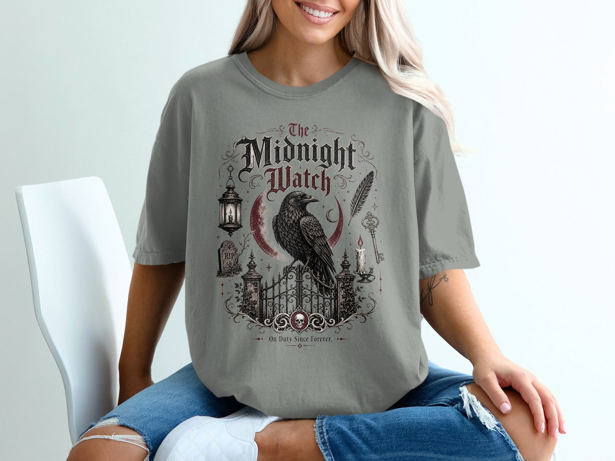 The Midnight Watch t-shirt design features a crow on a gate with gothic text and cemetery elements.