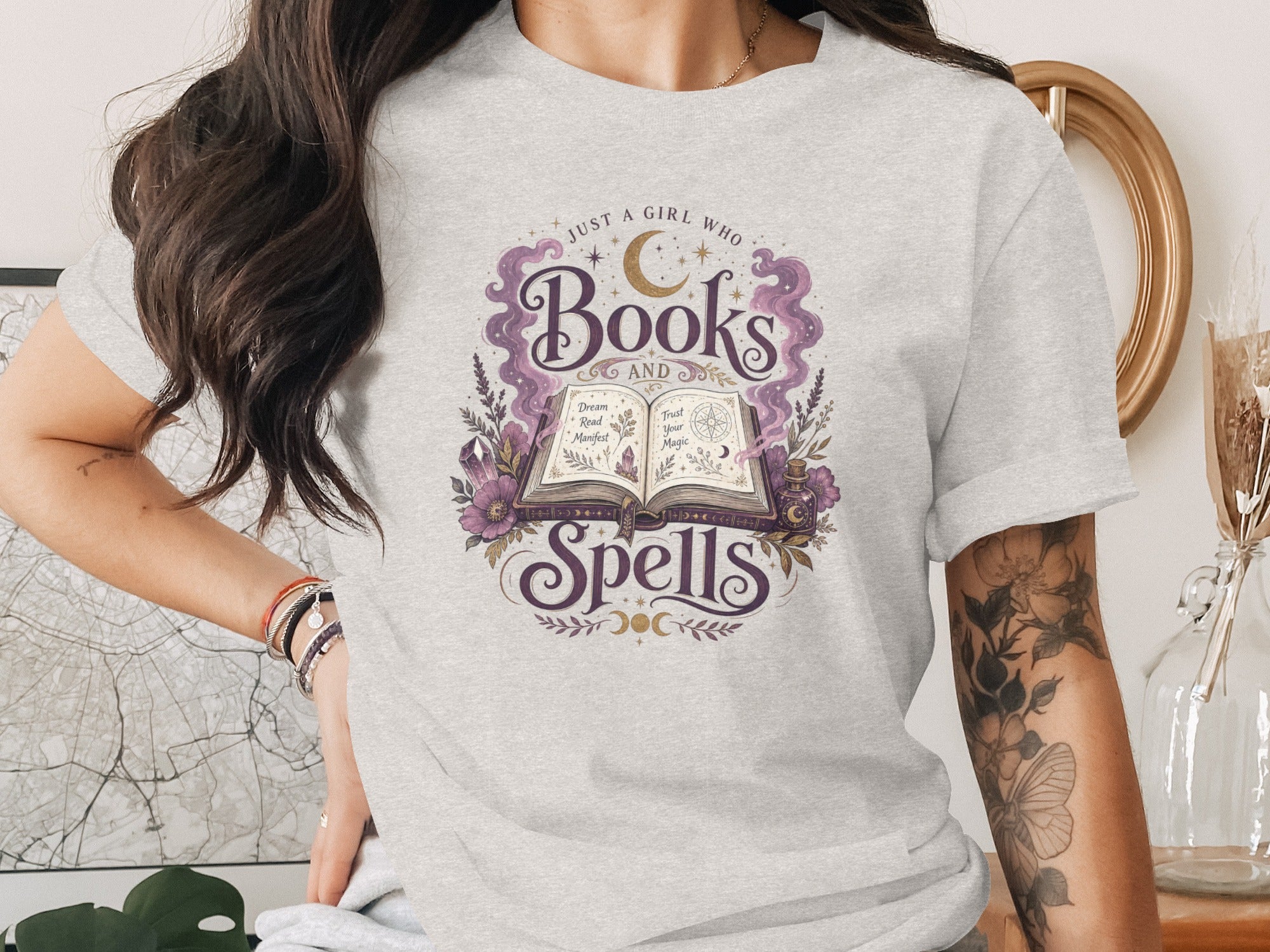 Light gray t-shirt with "Just a girl who Books and Spells" graphic.