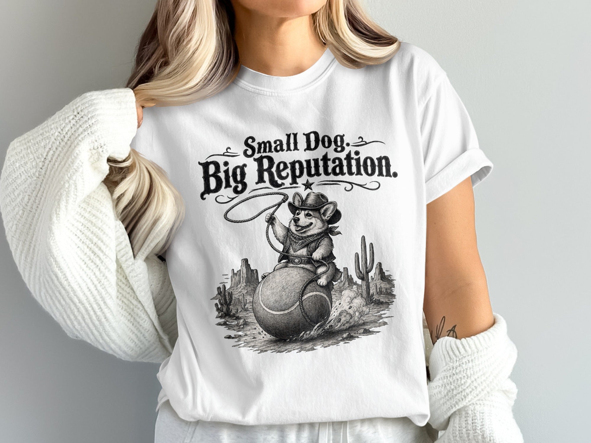 T-shirt with "Small Dog. Big Reputation." text and a dog riding a tennis ball in a desert.